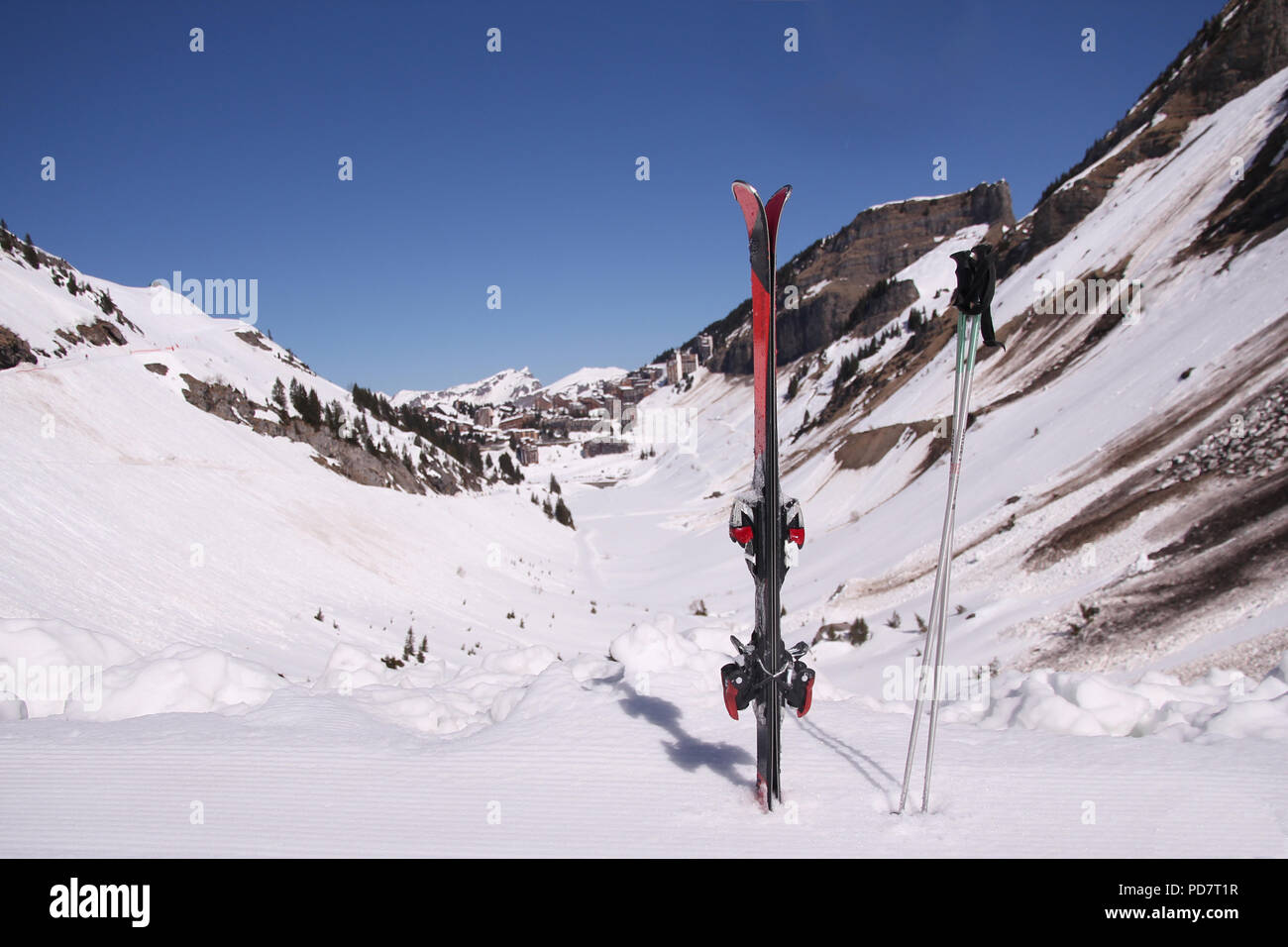 Ein paar Ski und Stöcke scharf mit einem weichen Fokus Aussicht auf die französischen Alpen Skigebiet Avoriaz, Portes du Soleil, im Hintergrund Stockfoto