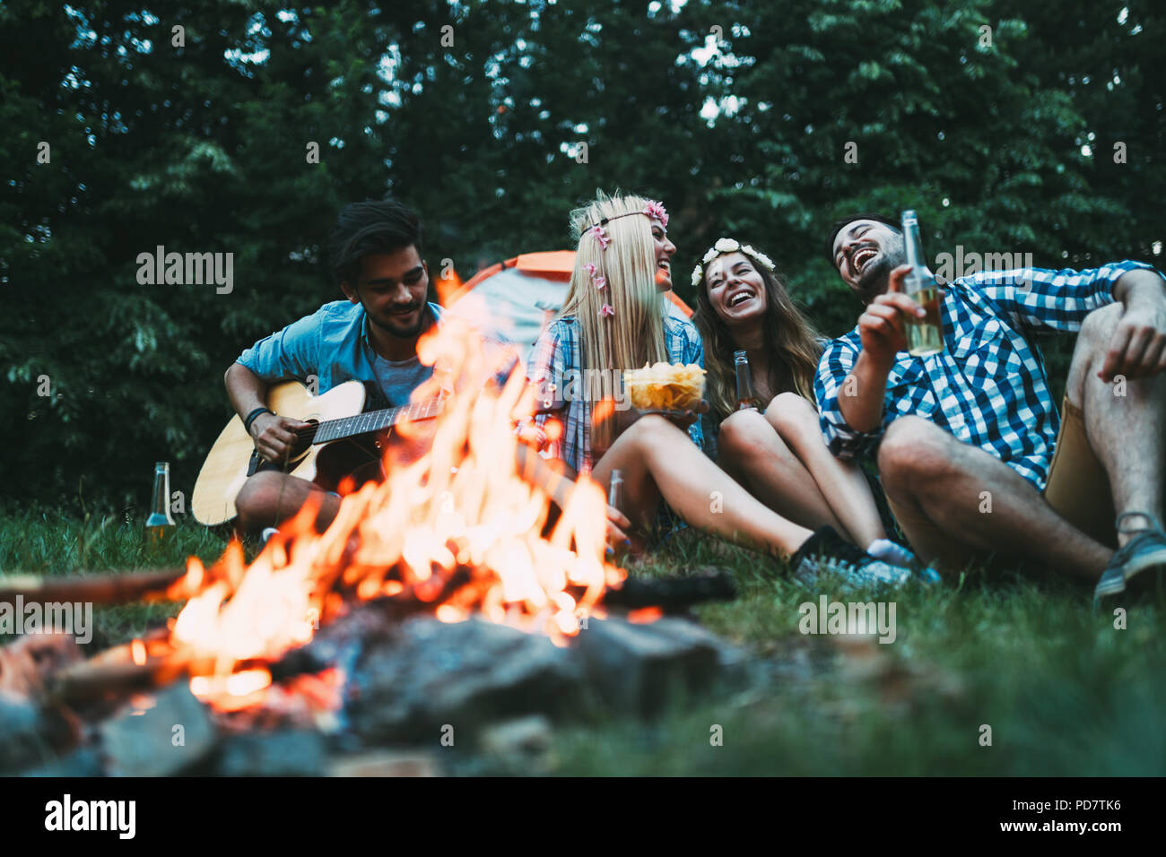 Fröhlicher junger Freunde Spaß durch Lagerfeuer Stockfoto