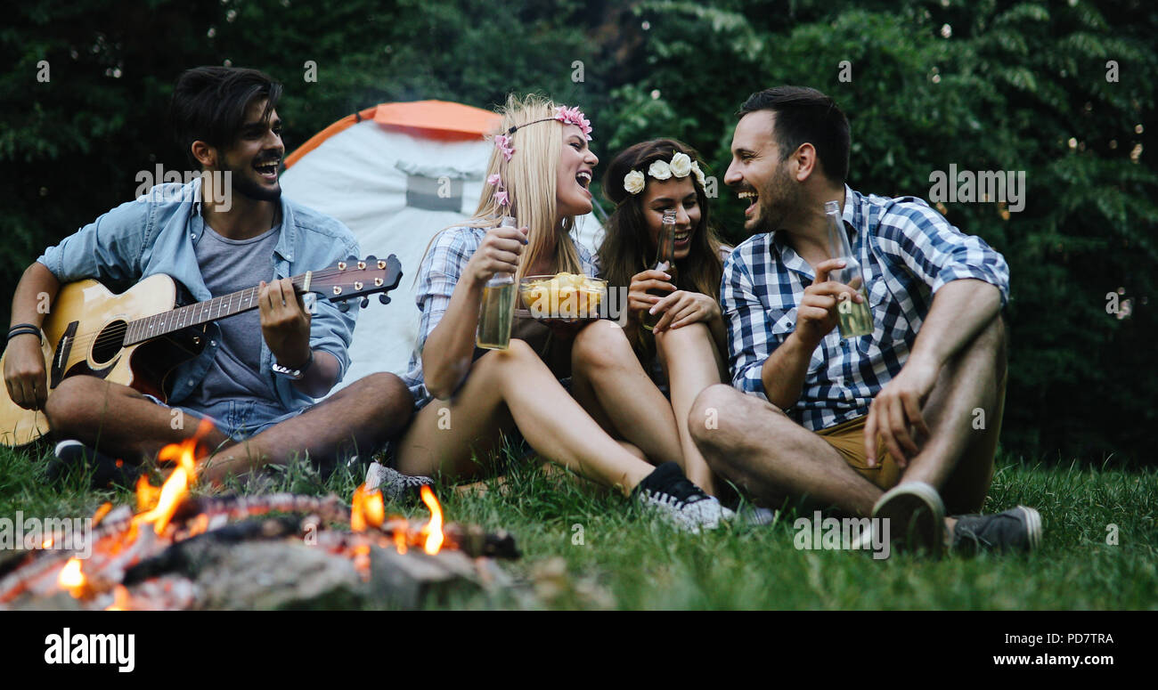 Gerne Freunde, Musik zu spielen und Lagerfeuer geniessen. Stockfoto