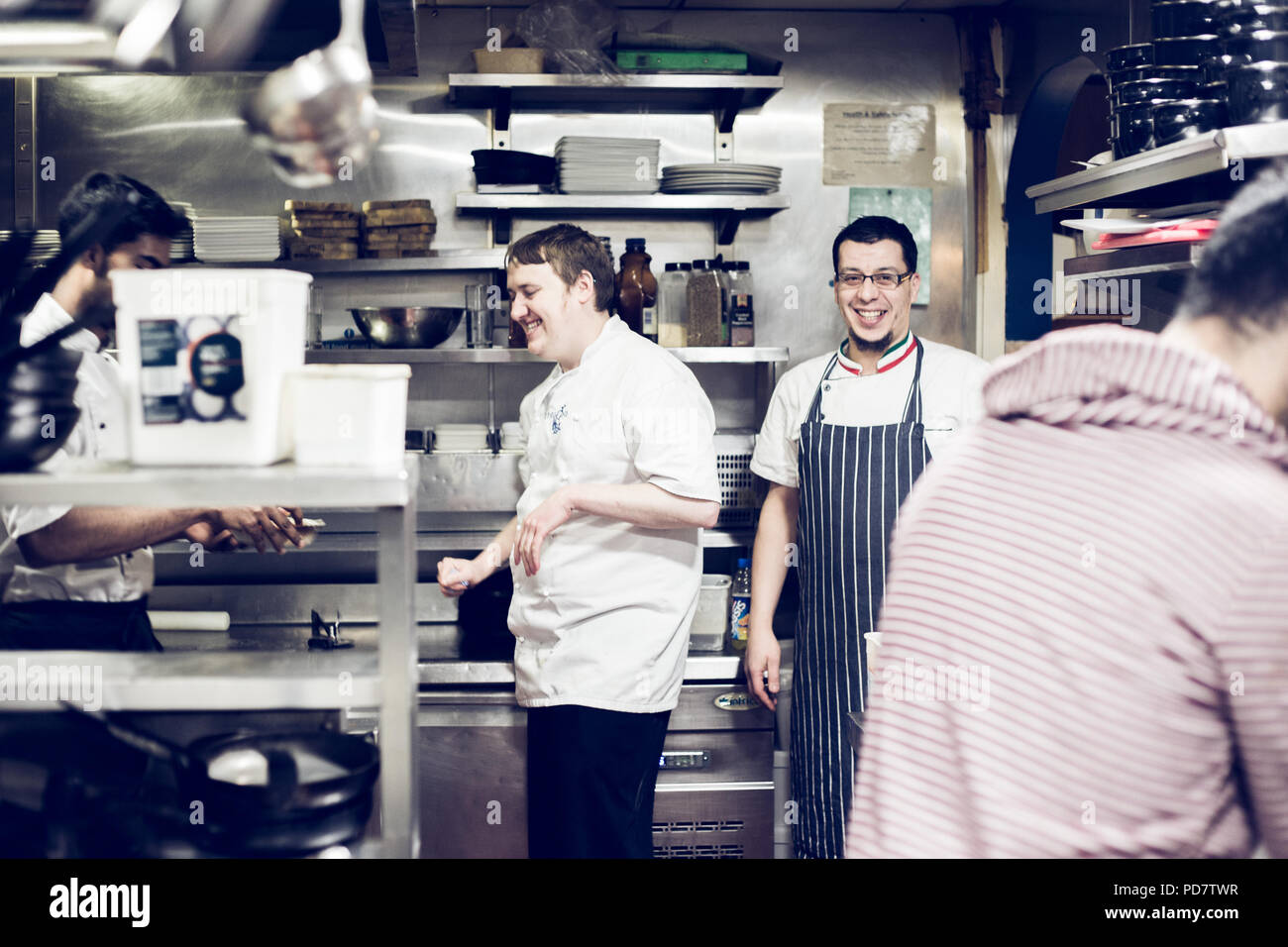 Köche in der italienischen Küche in einem Restaurant, die einen lustigen Moment zwischen den Service haben. Glasgow, Schottland Stockfoto