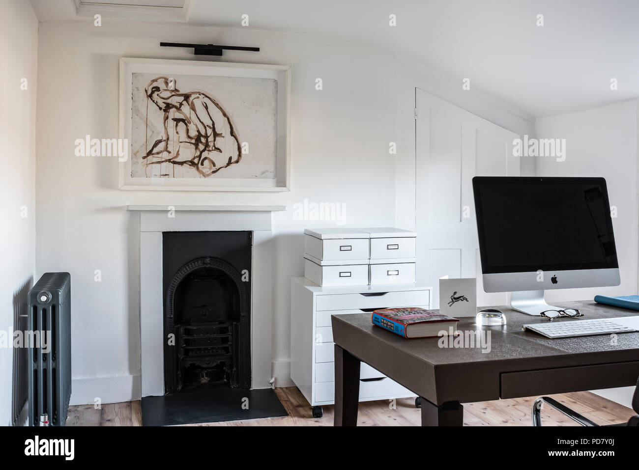 Schicke home-Office mit Holzboden und gerahmtes Aquarell von Ryan McElhinney, dem Arbeitstisch ist Philippe Hurel und Einreichung Bokes von Ikea Stockfoto