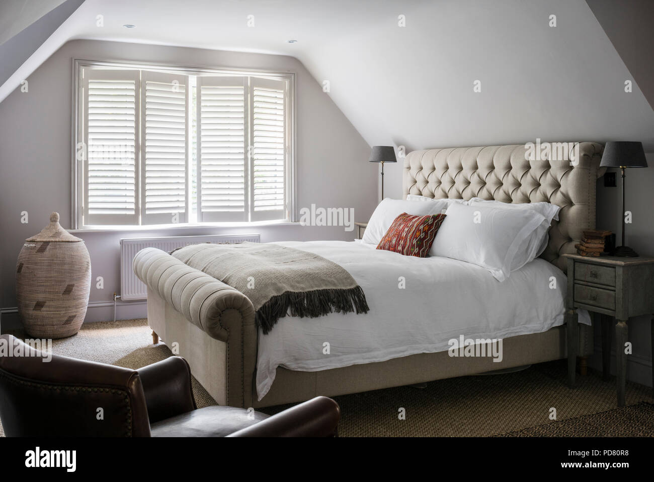 Pentlow knöpfbare Doppelbett aus Sofas und Material im Schlafzimmer mit Nachttischen von Cassia Bardoe Interior Design Stockfoto