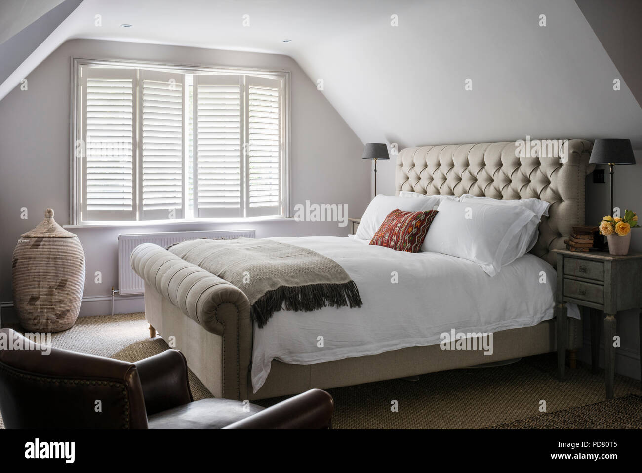 Pentlow knöpfbare Doppelbett aus Sofas und Material im Schlafzimmer mit Nachttischen von Cassia Bardoe Interior Design Stockfoto