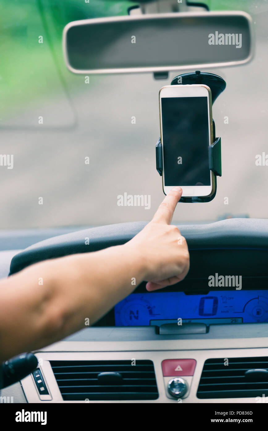Hand berühren auf Smart Phone in der Autohalterung naigation Optionen SMS zu ändern oder schreiben Stockfoto