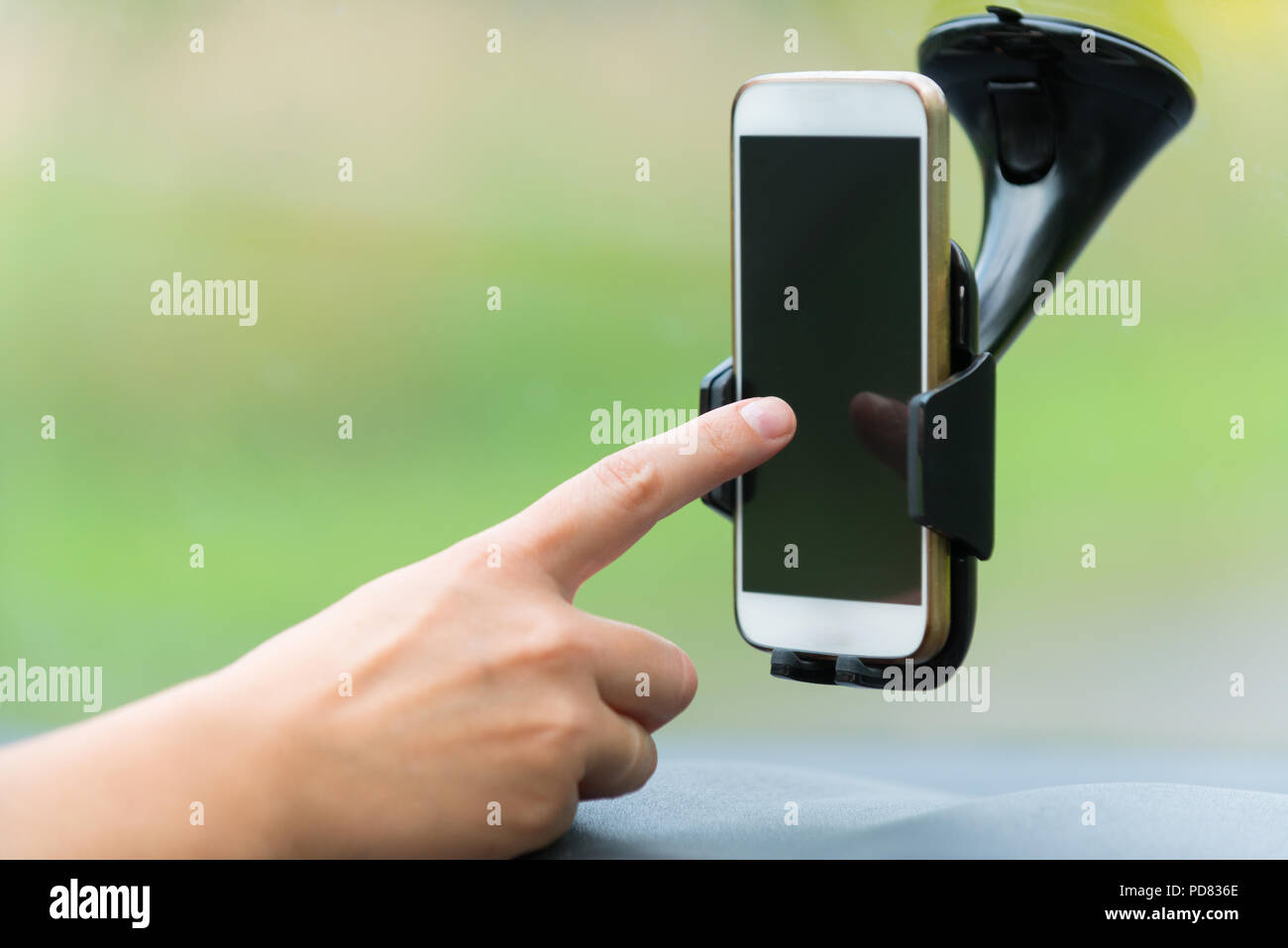Hand berühren auf Smart Phone in der Autohalterung naigation Optionen SMS zu ändern oder schreiben Stockfoto