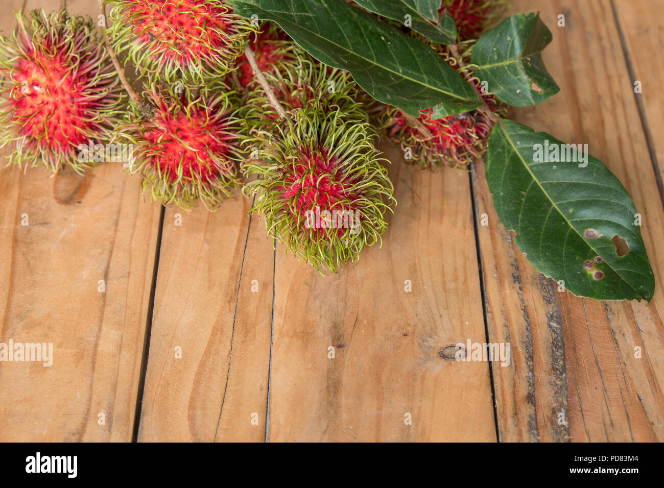 Roten rambutan Nephelium lappaceum auf broun Board. Obst tropischen Baum der Familie Sapindaceae, beheimatet in Südostasien, in vielen Ländern angebaut Stockfoto