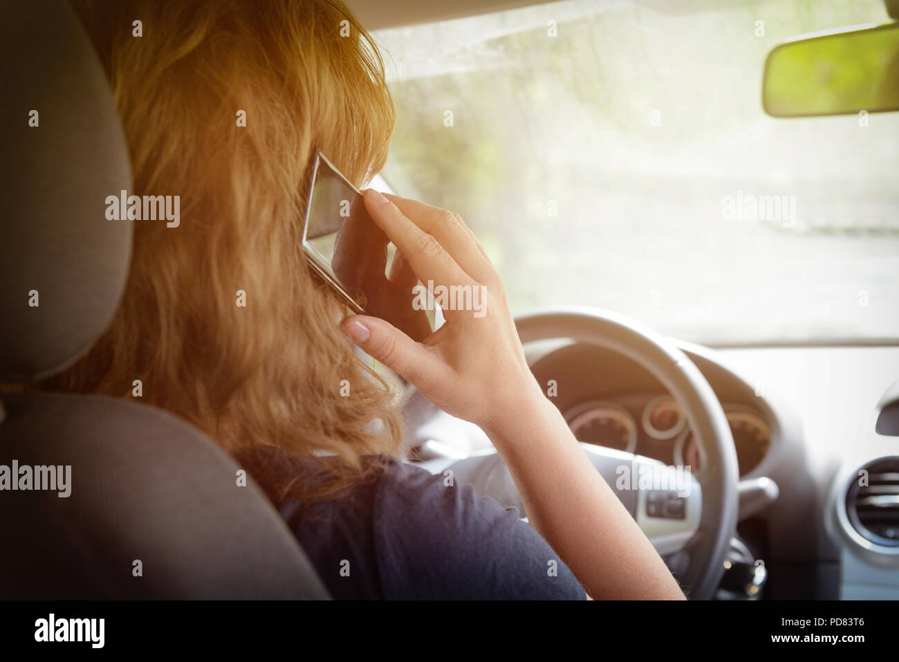 Frau mit Telefon, während das Auto fahren. Riskantes Fahrverhalten Konzept Stockfoto