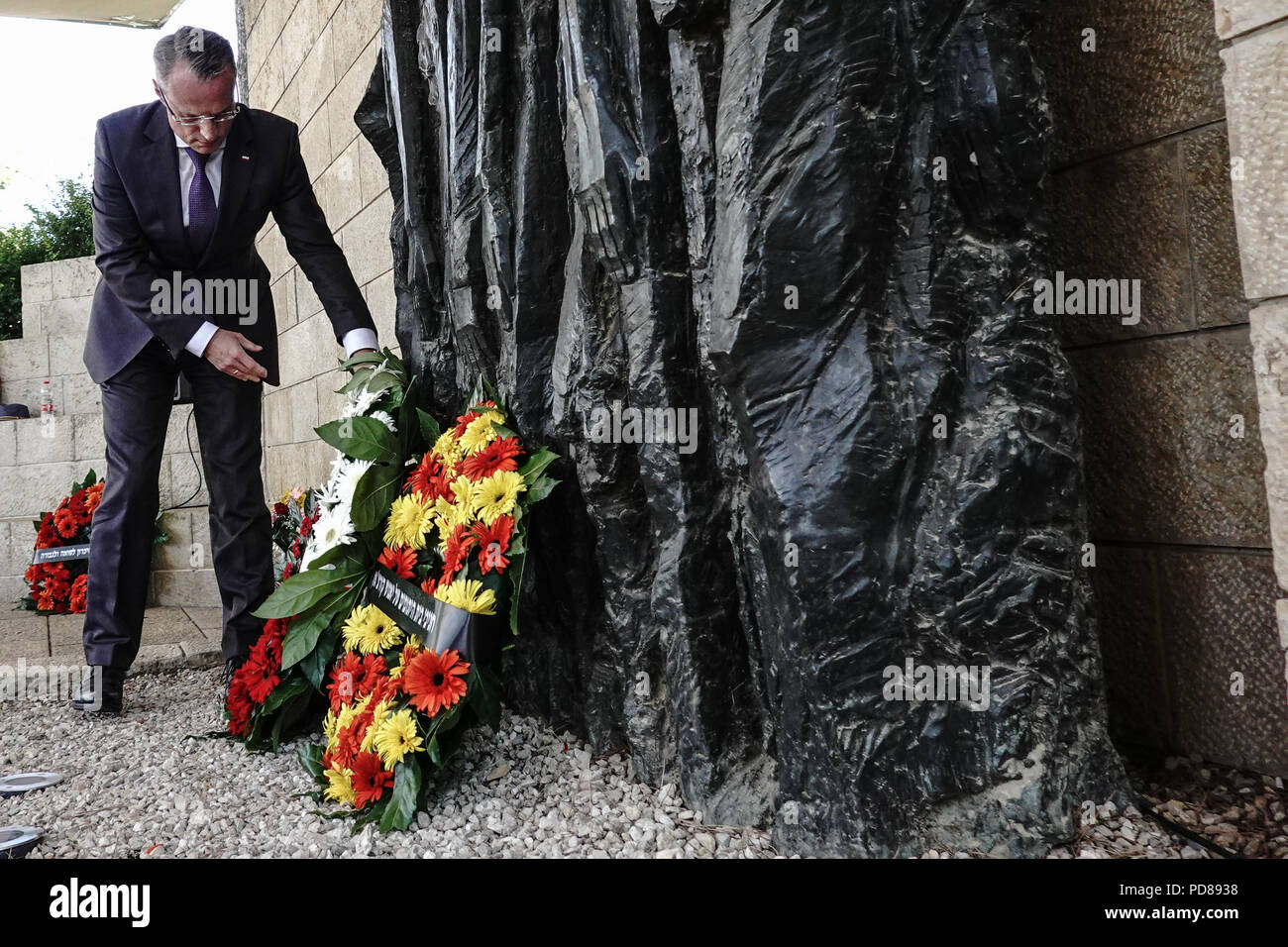 Jerusalem, Israel. 7. August 2018. Polnischer Botschafter in Israel, Marek Magierowski, Orte einen Blumenkranz am Fuße des "Korczak und die Ghetto Kinder" von Boris Saktsier in einer Trauerfeier Kennzeichnung 76 Jahre seit dem Tod von Janusz Korczak. Korczak, Henryk Goldszmit im Jahre 1878 geboren, ein polnisch-jüdischen Erzieher und Kinderarzt, Leiterin eines Waisenhauses in Warschau, persönliche Freiheit verweigert, und begleitet seine 200 Waisen, in die Vernichtungslager Treblinka, wo Sie alle 1942 ausgerottet wurden gezwungen. Credit: Nir Alon/Alamy leben Nachrichten Stockfoto