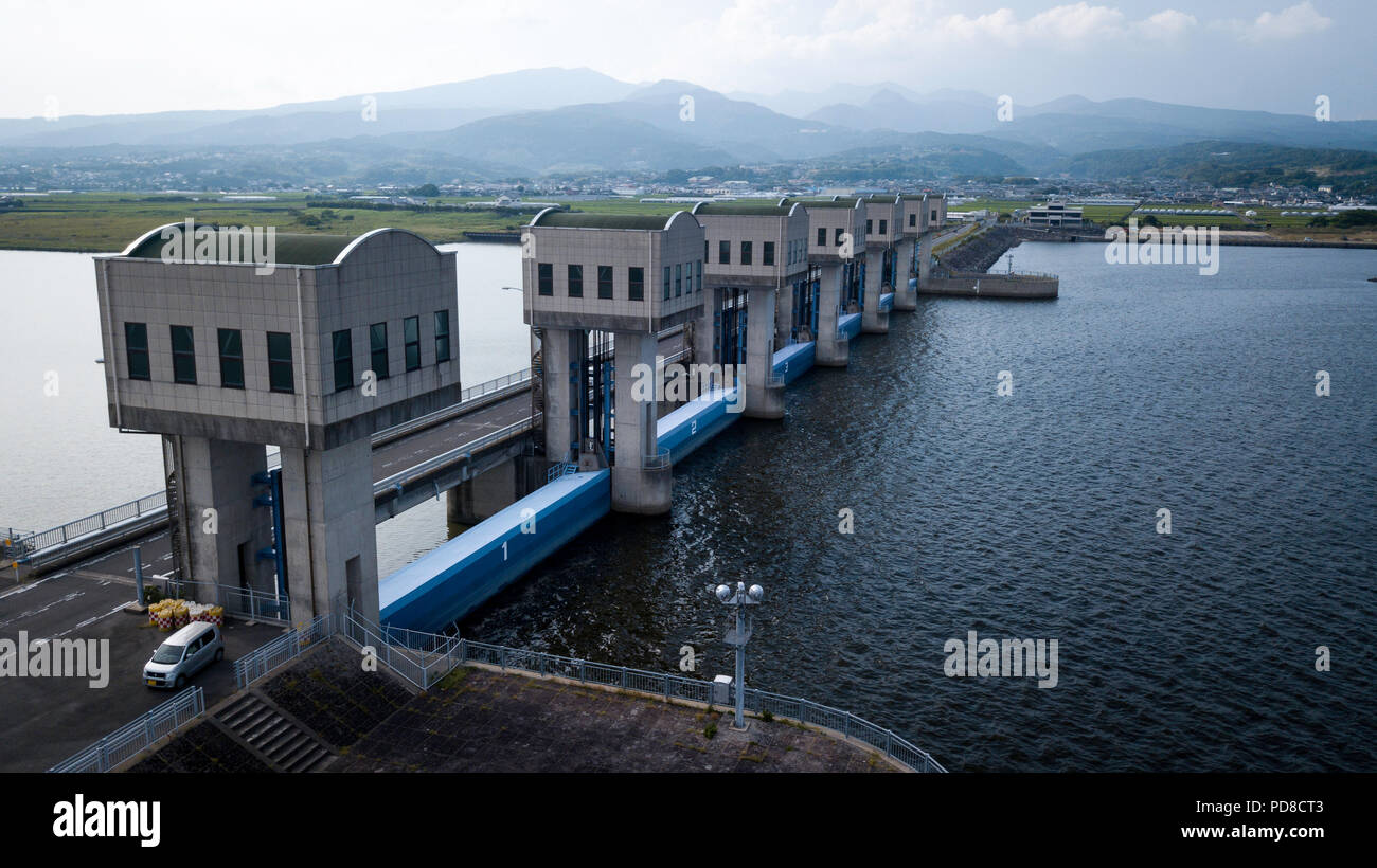 ISAHAYA, Japan - 07 AUGUST: Foto am 7. August, 2018 zeigt eine Schleusen (vorne) des Isahaya Bay Deich in Nagasaki, Japan. Eine große Fläche des Gezeiten Land, nachdem die Regierung im Jahr 1997 verschwunden geschlossen eine Wand der Schleusen in der Bucht im westlichen Teil der Ariake See für eine Landgewinnung Projekt. Seitdem sind eine Reihe von Klagen über das Projekt eingereicht wurde, nicht nur die Fischer, sondern auch die Landwirte, die zurückgewonnenen Landes. Die Regierung wurde bestellt, einige der Schleusen für eine Umweltverträglichkeitsprüfung zu öffnen, aber es war nicht eingehalten. (Foto: Richard Atrero de Guzman/LBA) Stockfoto