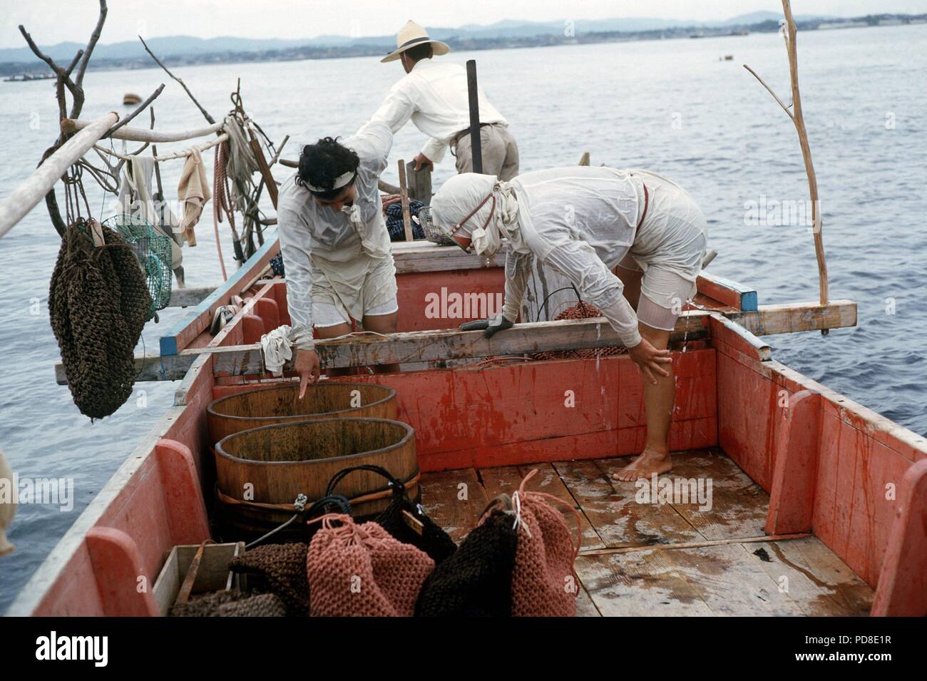 Zwei Ama Taucher haben mit dem Boot nach der Arbeit mit ihr Ertrag (in der woodchiefs) Verankerung in der Nähe der Pearl Island Toba auf der Halbinsel Shima. (Undatierte Aufnahme). Zuchtperlen, wie natürlich gewachsen Perlen, sind in der perlmuschel durch eine Trennung von Mutter gebildet - von - Perle um ein Fremdkörper in der Shell. Für die Zucht dieser Fremdkörper ist absichtlich in den jungen Perl Austern hinterlegt. Wie in der natürlichen Prozess, es dauert etwa sieben Jahre für eine Perle, um zu reifen. Die perlmuscheln sind 'geerntet' durch die so genannte Ama Frauen, die Japaner Pearl Diver. | Verwendung weltweit Stockfoto