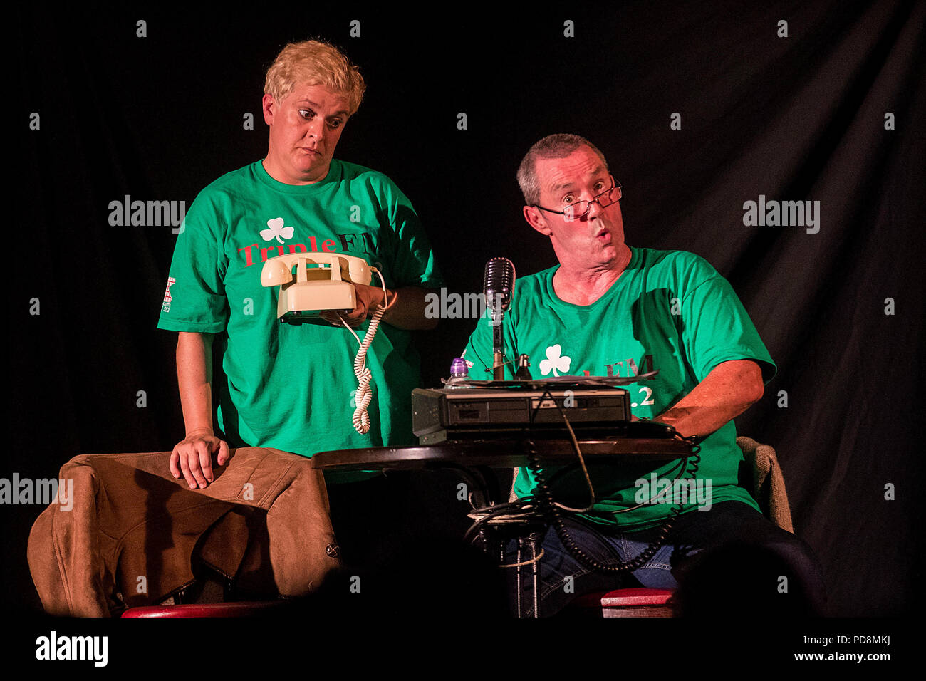 Die Schauspieler Jo Donnelly und Martin Maguire (rechts) während der Aufführung von Tony Devlins Stück „A Station Once Again“ im Roddy McCorley Social Club, das sich an den West-Radiosender „Triple FM“ in Belfast während des 30. Jahres des Feile an Phobail (The Community's Festival) erinnerte. Stockfoto