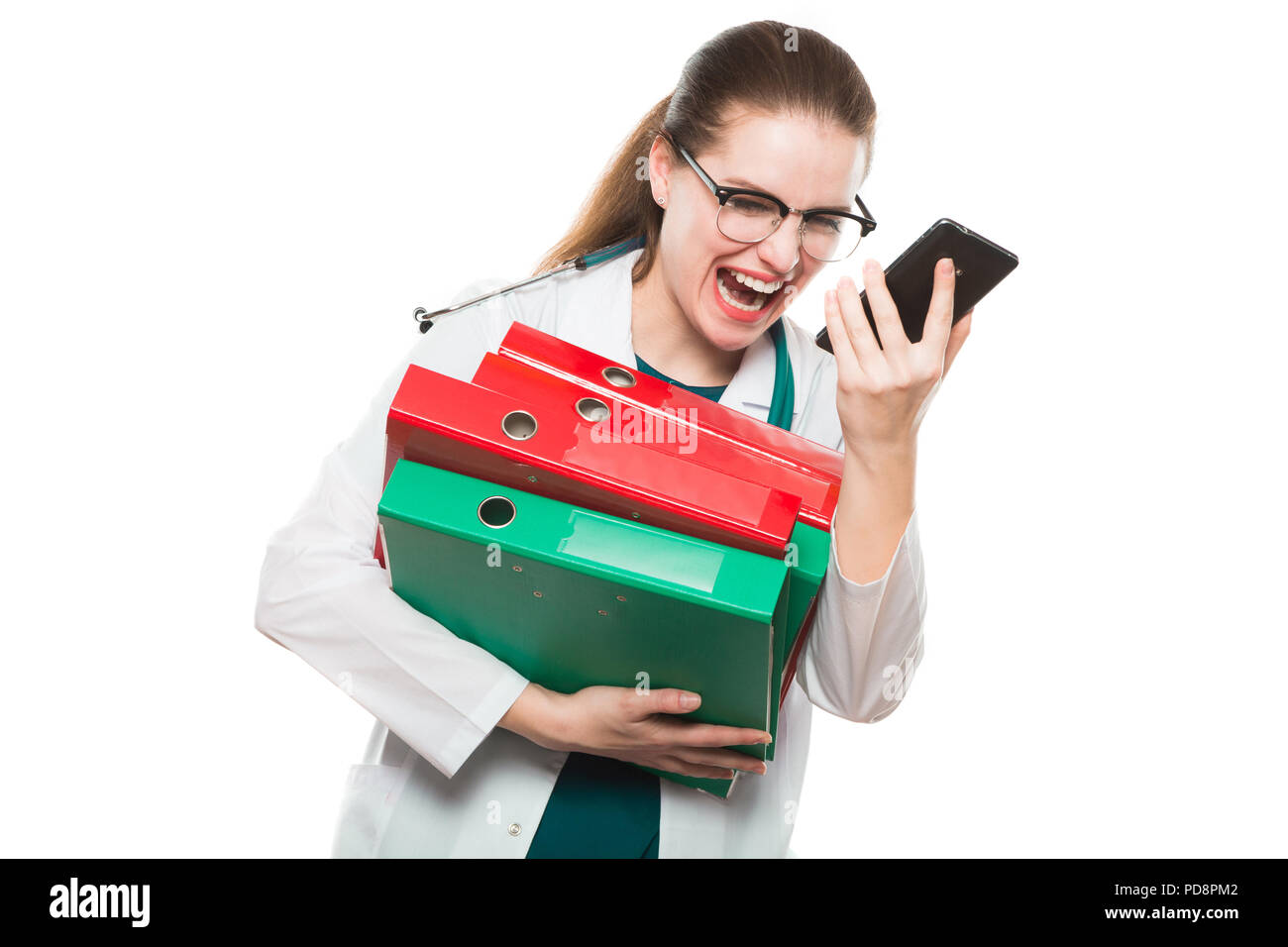 Attraktive kaukasische brunette wütend Ärztin stehen im Büro mit Bindemittel in ihre Hände auf weißem Hintergrund in Ihrem Telefon schreien Stockfoto