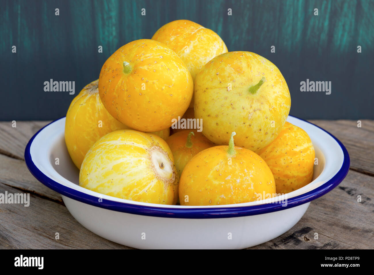 Zitrone Gurken, auch als Cucumis sativus auf einem rustikalen Holzmöbeln Hintergrund bekannt. Stockfoto
