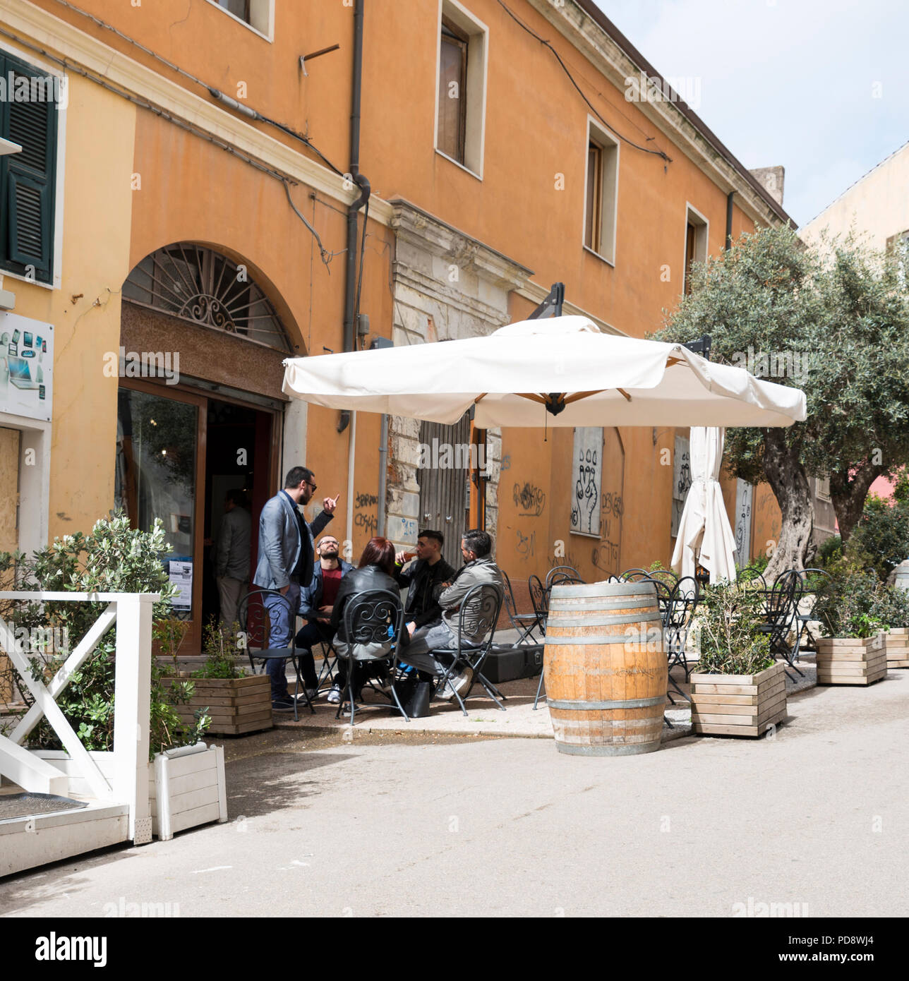 Sassari, Italien, 12. April 2018: Mann sitzt auf einer Terrasse in der Sonne in Sassari Sassari ist eine der größten Städte des Westen Sardinien Stockfoto