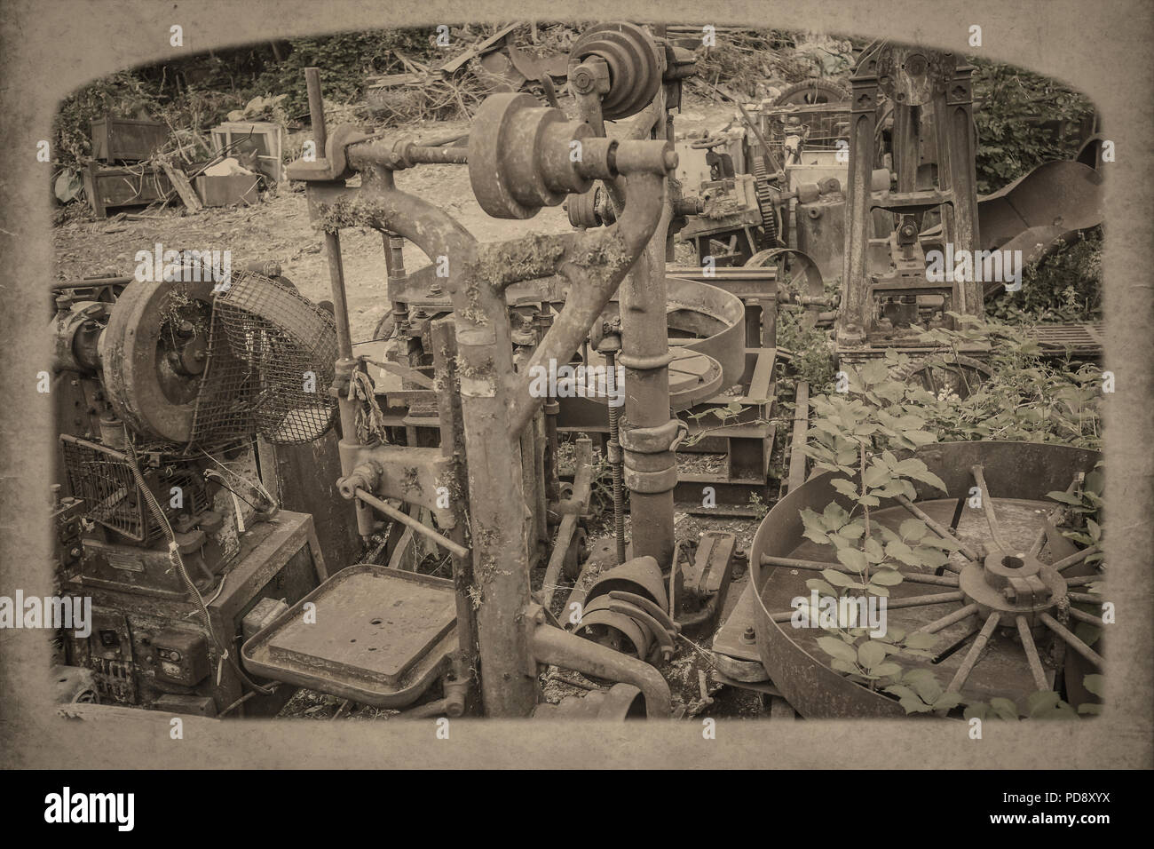 Arty, nostalgische, Landschaft schoss der abgebrochenen, vernachlässigt, industrielle Metallbearbeitung Teile in der äußeren Umgebung, mit Unkraut überwuchert. Vintage sepia Effekt. Stockfoto