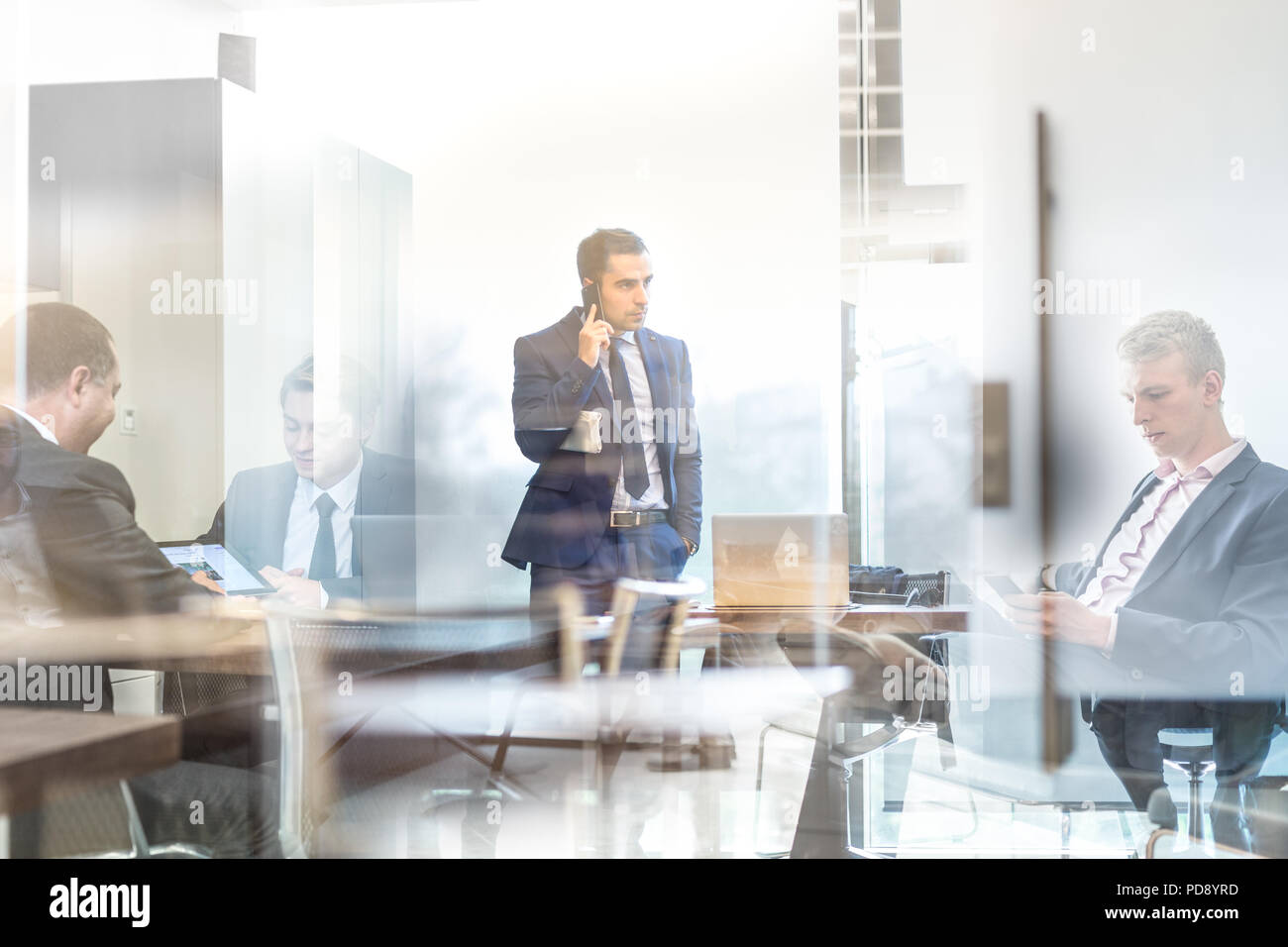 Unternehmer im Gespräch mit einem Mobiltelefon auf Unternehmensebene ab. Stockfoto