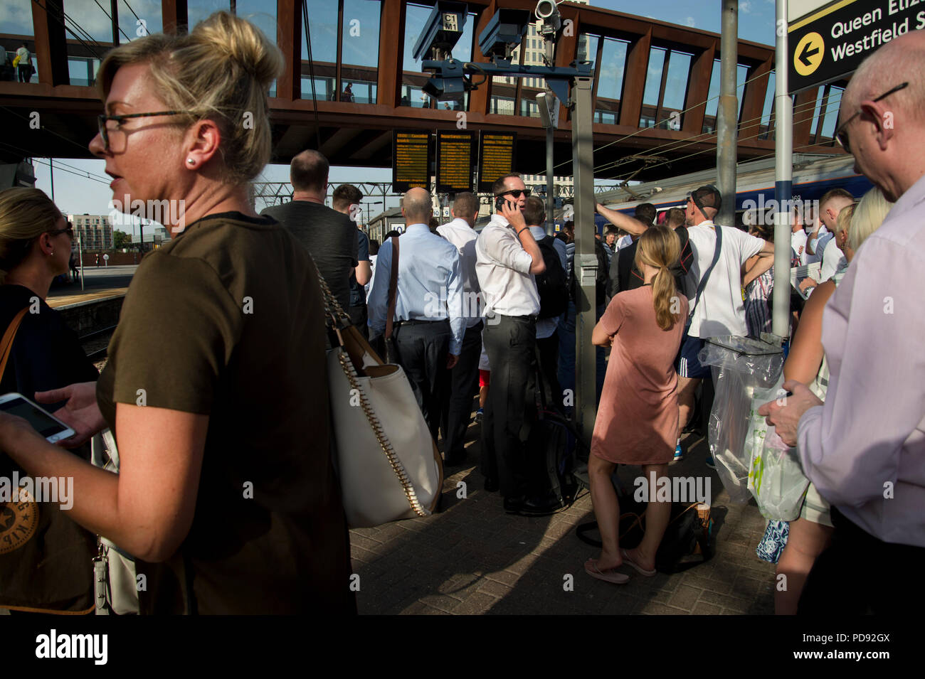 Der Bahnhof Stratford, London. Rush Hour an einem heißen Abend. Pendler warten auf einen verspäteten Zug zu gelangen Stockfoto