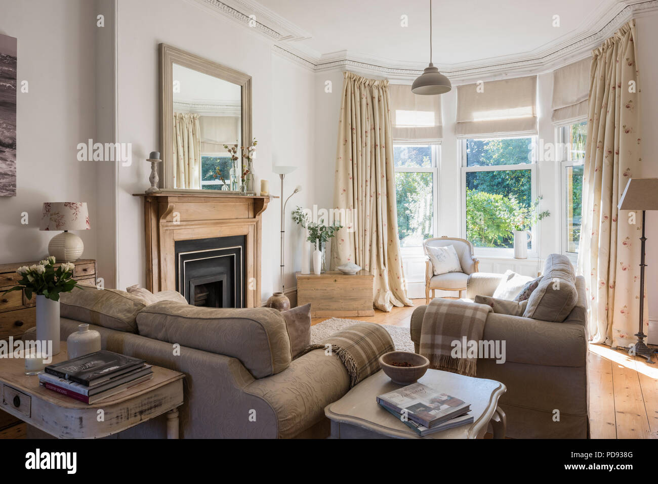 Debenham Sofas in hellen Wohnzimmer mit antiken französischen Vorsitz Stockfoto
