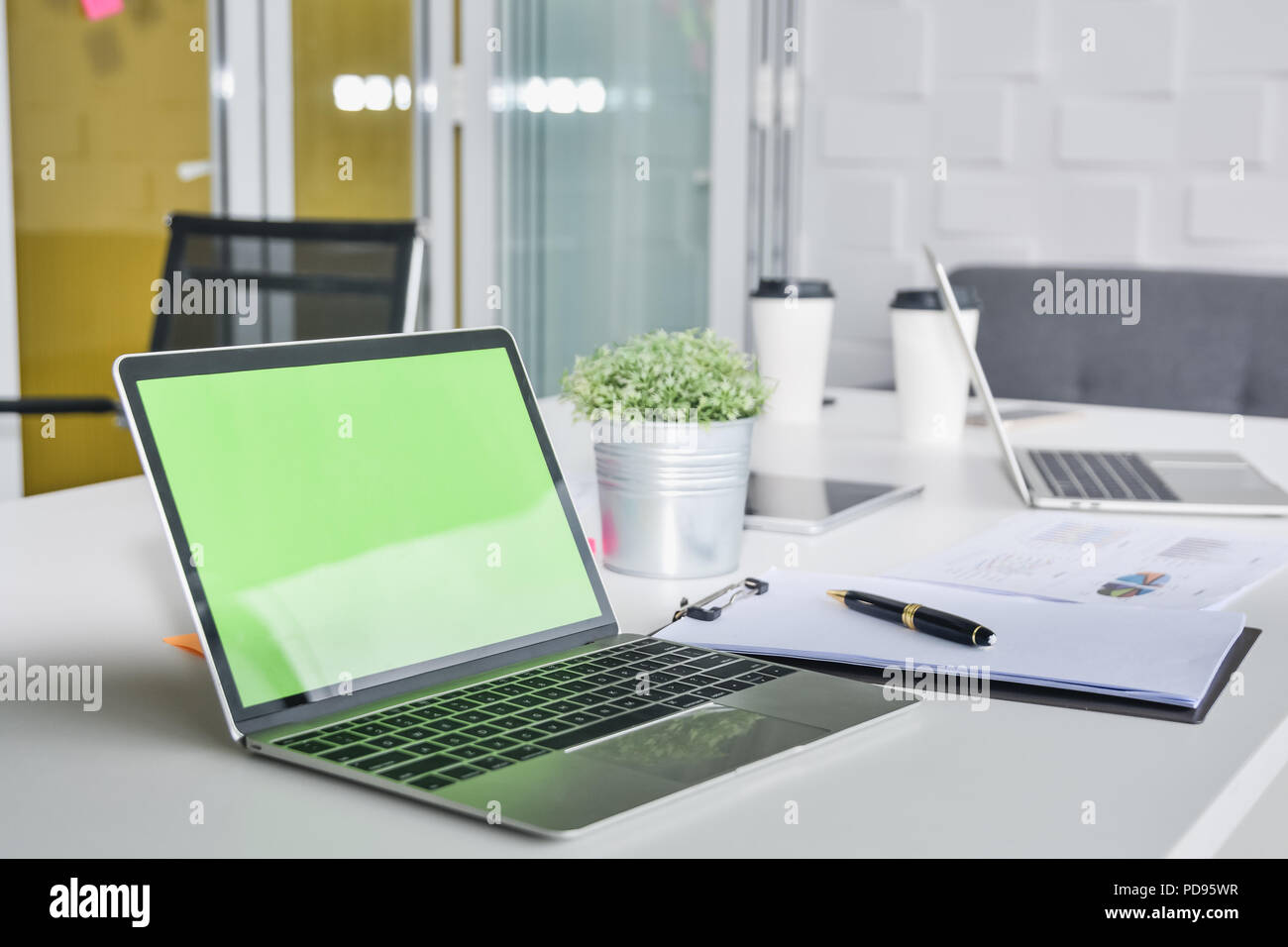 Büro Arbeitsplatz mit leerer Bildschirm Laptop und Bürobedarf in Konferenzraum Arbeitsbereich Stockfoto