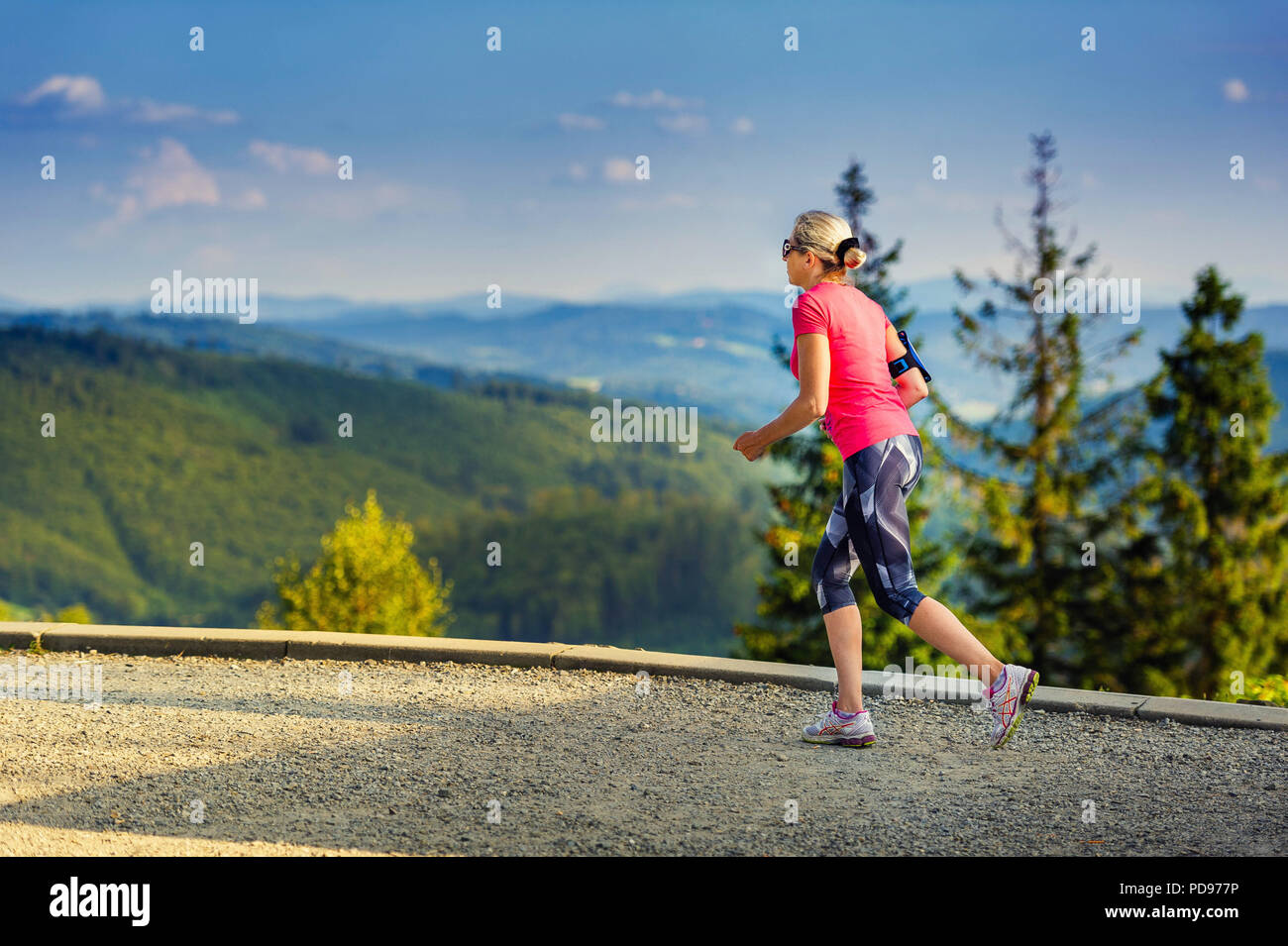 Junge Frau läuft in den Bergen Stockfoto