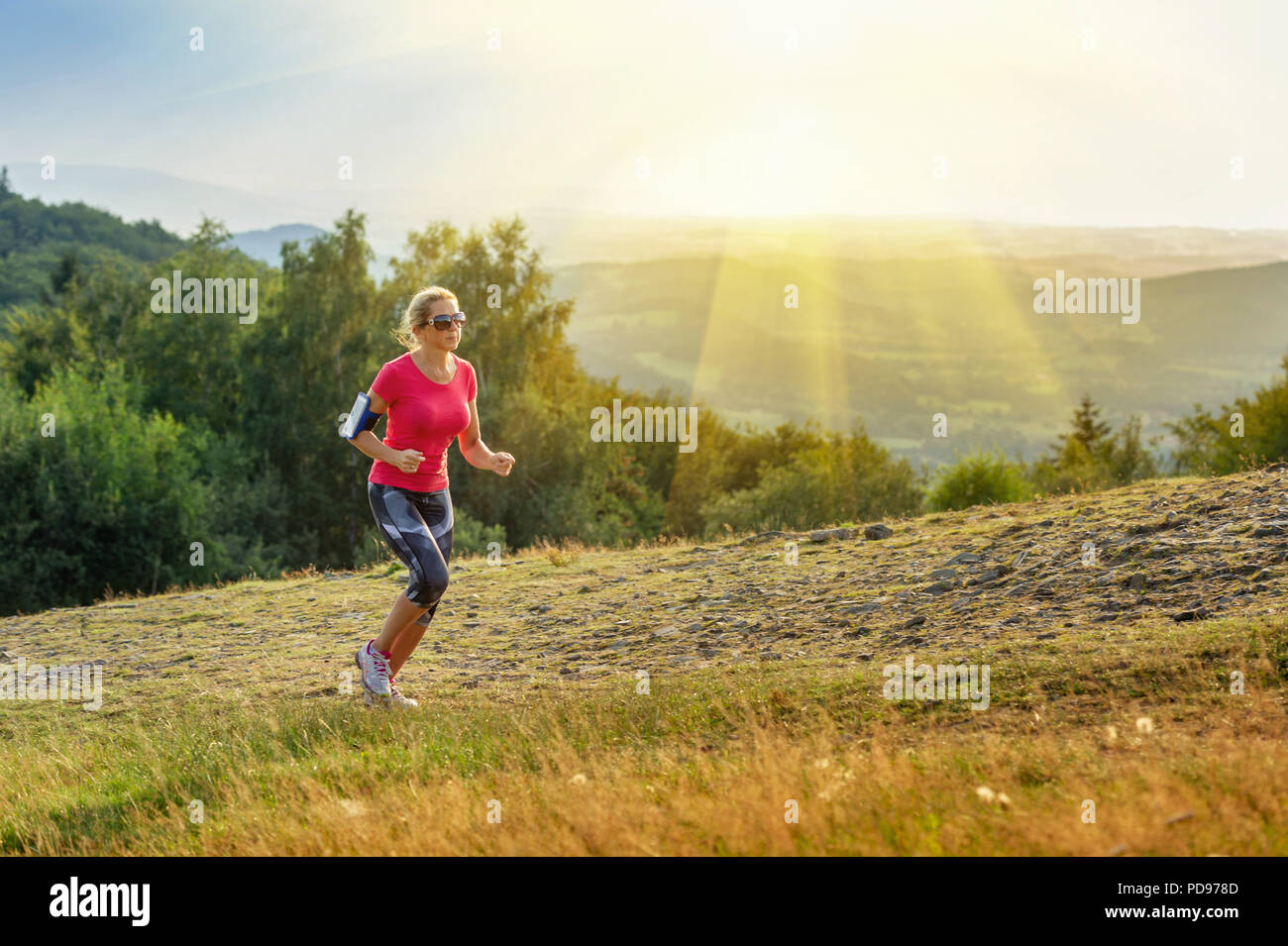 Junge Frau läuft in den Bergen Stockfoto