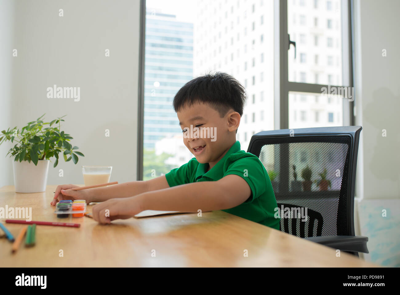 Nett lächelnden jungen Hausaufgaben, Malvorlagen, Schreiben und Malen. Kinder malen. Kinder ziehen. Vorschüler mit Büchern in der Bibliothek. Bunte pen Stockfoto