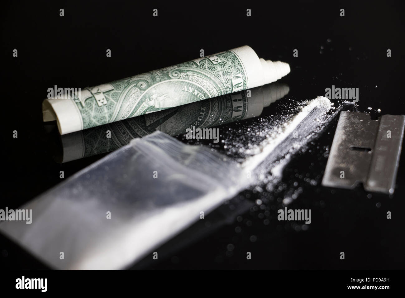 Partydrogen, Kokain, baggie, Rasierklinge und rollte bis Geld auf einem schwarz glänzenden, reflektierender Oberfläche. Stockfoto