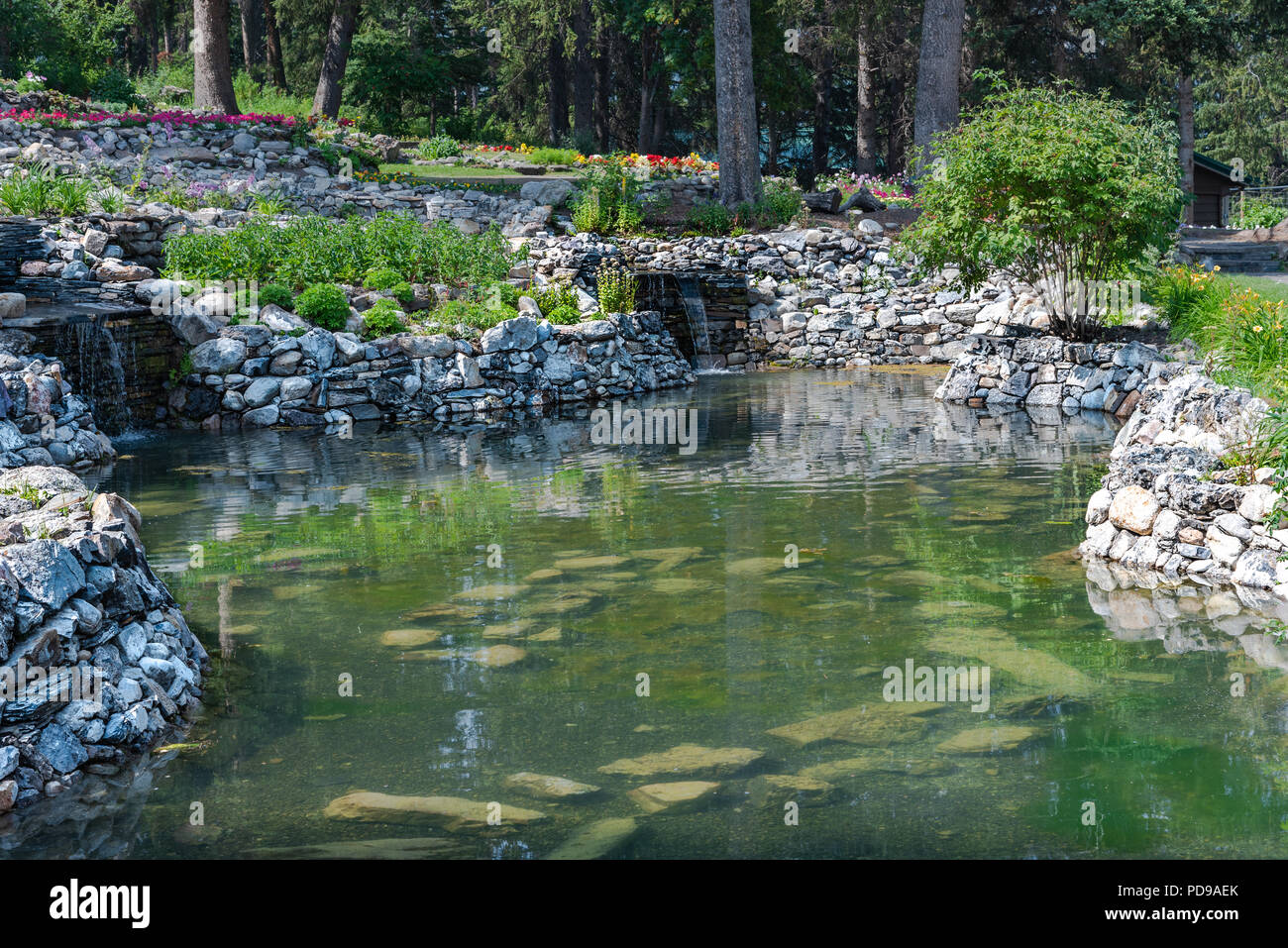 Ein Teich mit Steinmauern in Banff Garten. Stockfoto