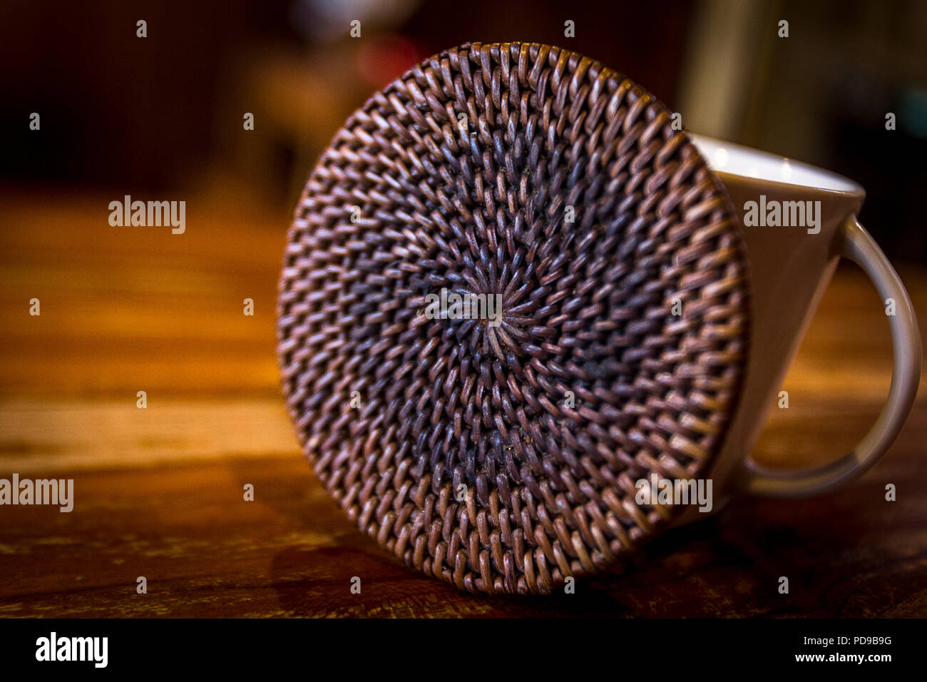 Gewebte Rost farbigen Achterbahn sitzt wie ein Rad neben einem weissen Kaffeetasse. Stockfoto