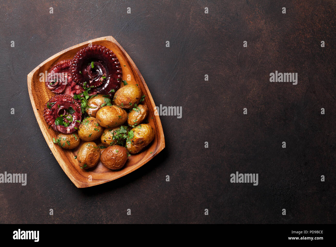 Gegrillter Tintenfisch mit kleinen Kartoffeln mit Kräutern und Gewürzen. Ansicht von oben mit Platz für Ihren Text Stockfoto