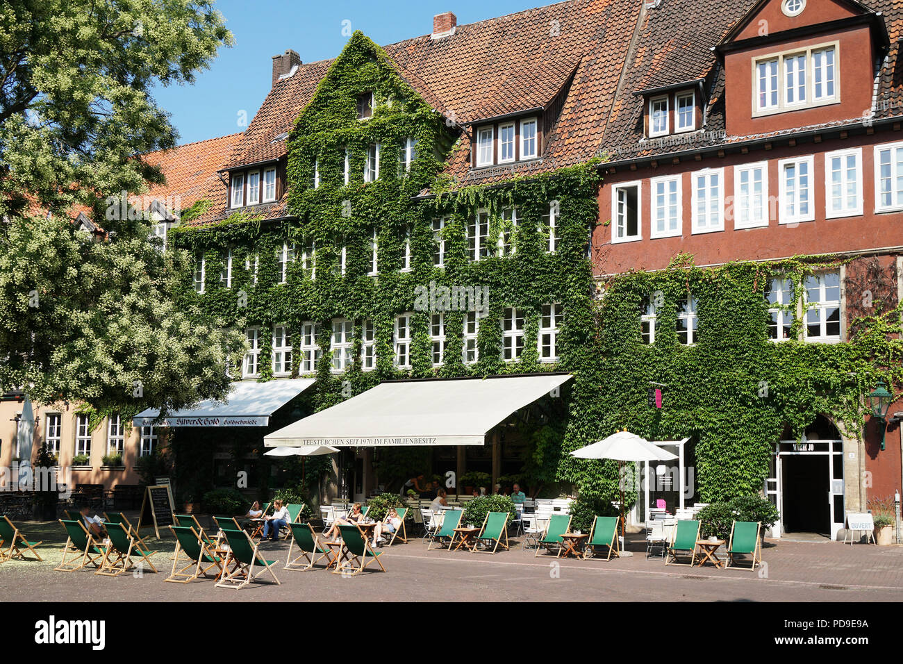 Hannover, Deutschland - Sommer 2018: Ballhofplatz Square mit Liegestühlen vor beliebtes Café Teestübchen (d. h. wenig Kaffee Zimmer) in der Altstadt Stockfoto