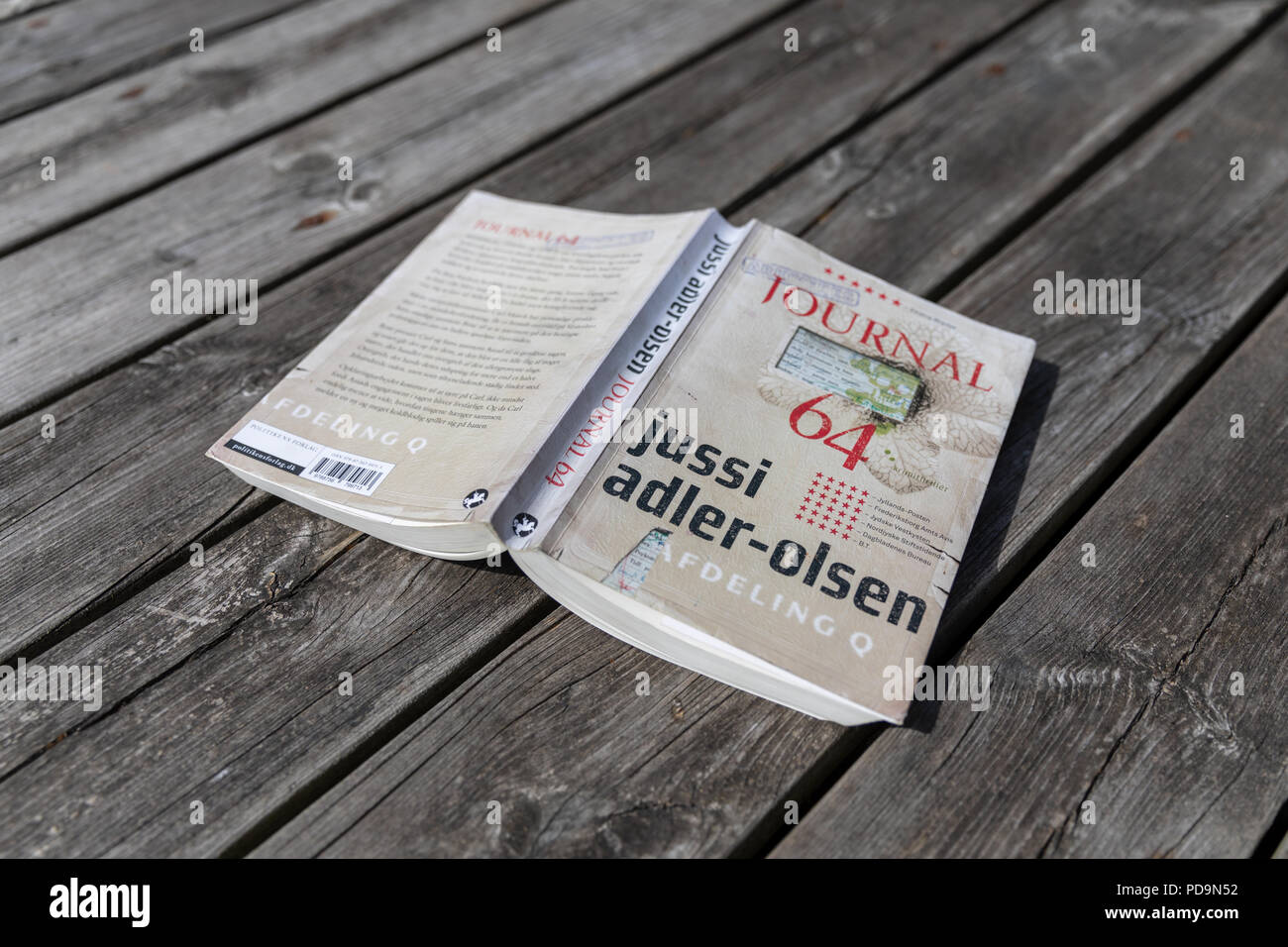 ' Journal 64', Jussi Adler-Olsen Roman (Dänisch) auf hölzernen Terrasse Stockfoto