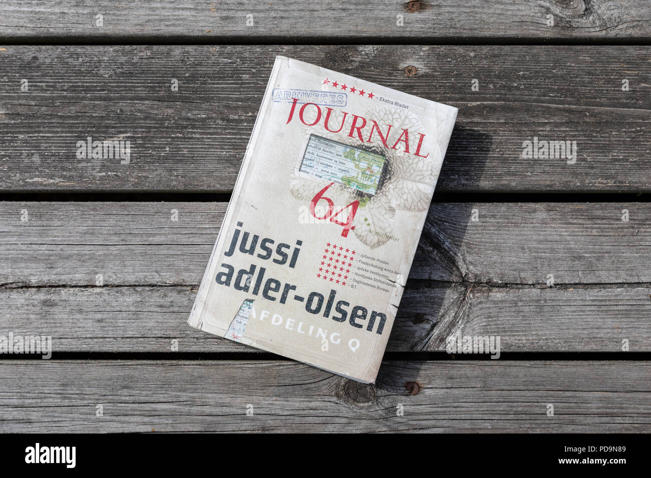 ' Journal 64', Jussi Adler-Olsen Roman (Dänisch) auf hölzernen Terrasse Stockfoto