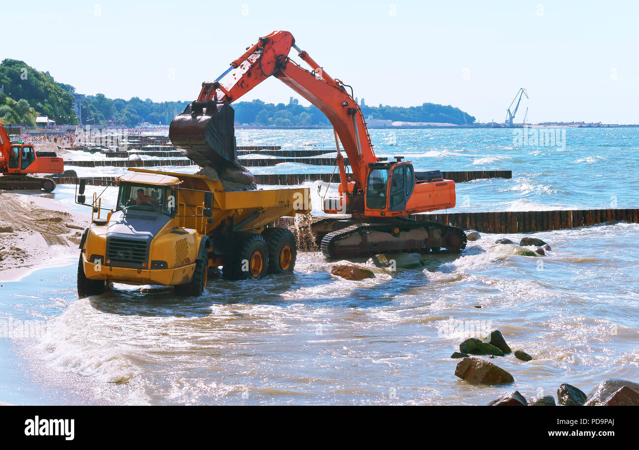 Baumaschinen auf dem Ufer, den Bau von Wellenbrechern, Küstenschutz Maßnahmen Stockfoto