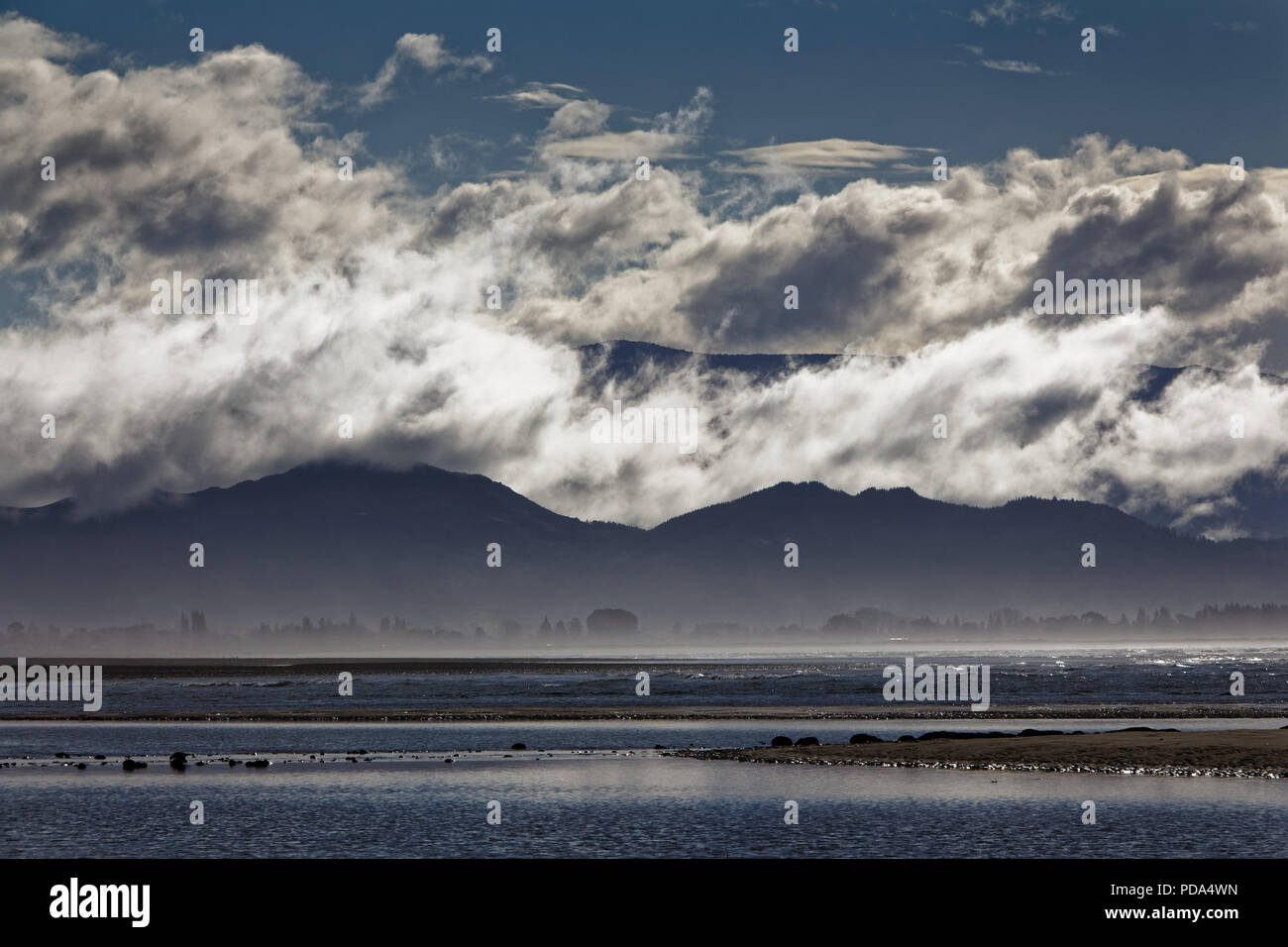 Cloud Schichten auf den Hügeln über Kina Strand gesehen Neuseeland Stockfoto