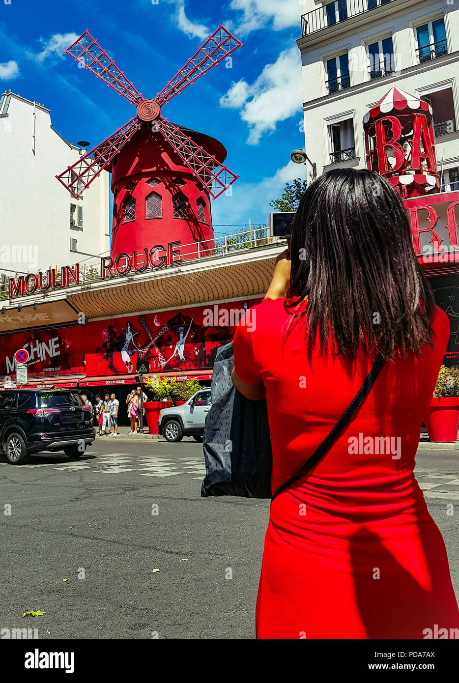 PARIS, Frankreich, 28. Juli 2018: Ansicht von hinten von einer Frau im roten Kleid fotografieren des berühmten Moulin Rouge Fassade in Paris. Stockfoto