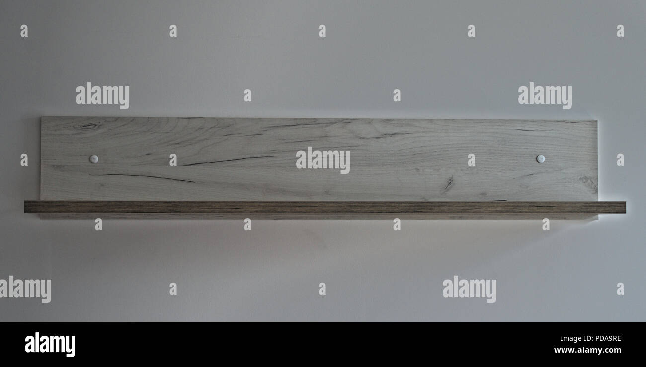 Leere graue Holzregal auf weiße Wand, Vorderansicht Stockfoto
