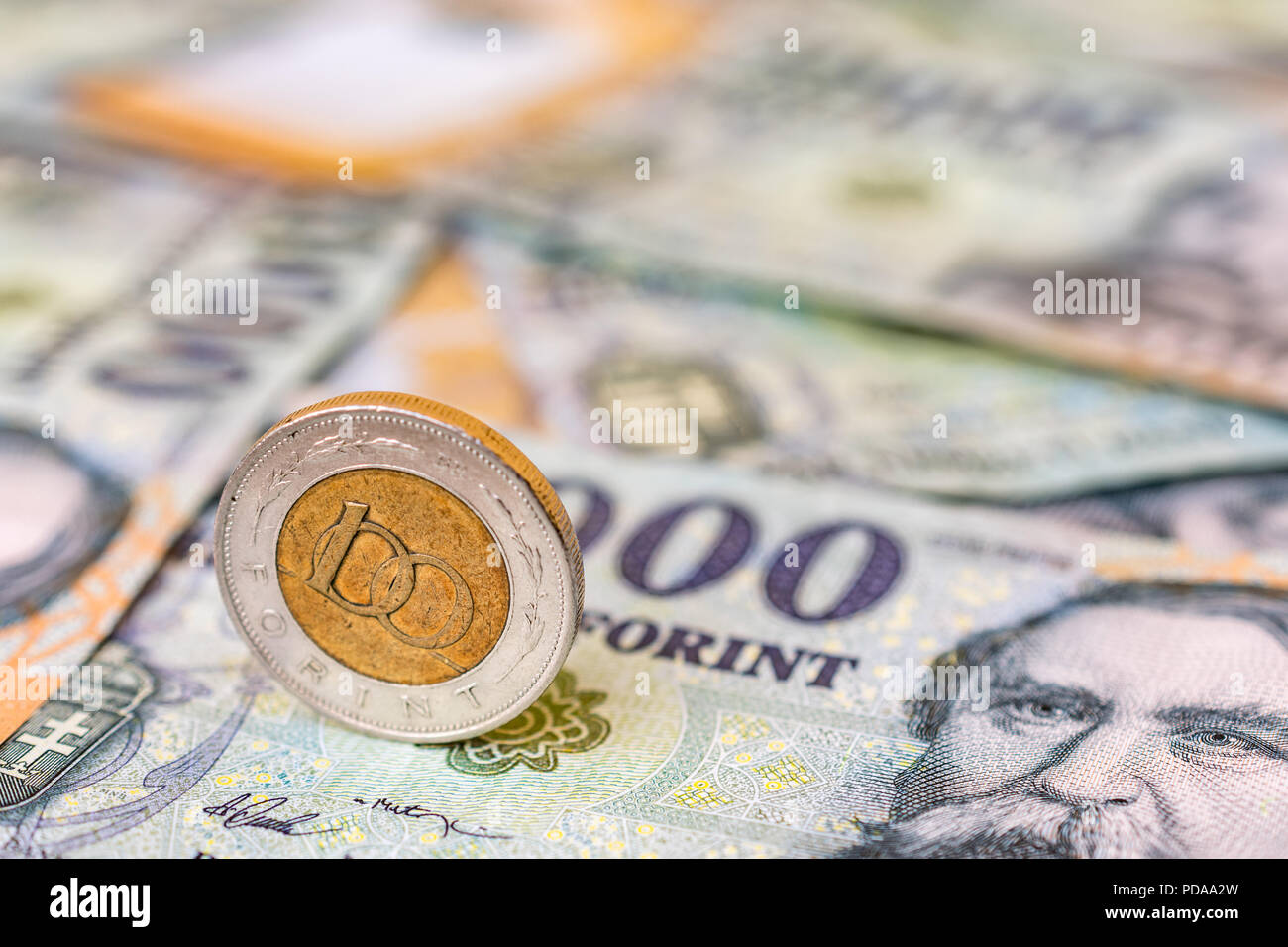 Ungarn 100 Forint Münze hochkant auf 20000 Forint Banknoten Stockfoto