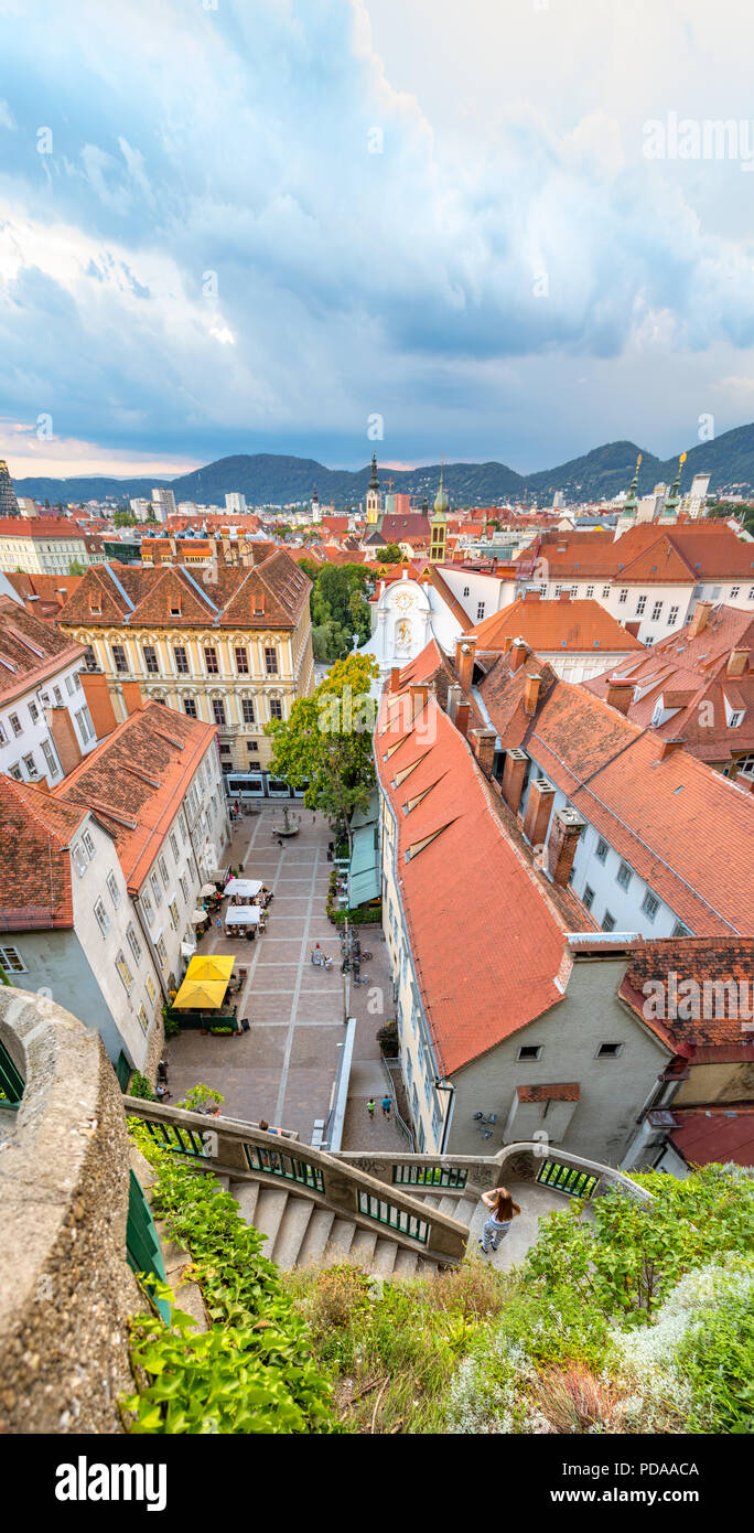 Vertikale Panorama auf die Altstadt von Graz. Blick von der Burg auf die Skyline der Stadt während des Sonnenuntergangs. Stockfoto