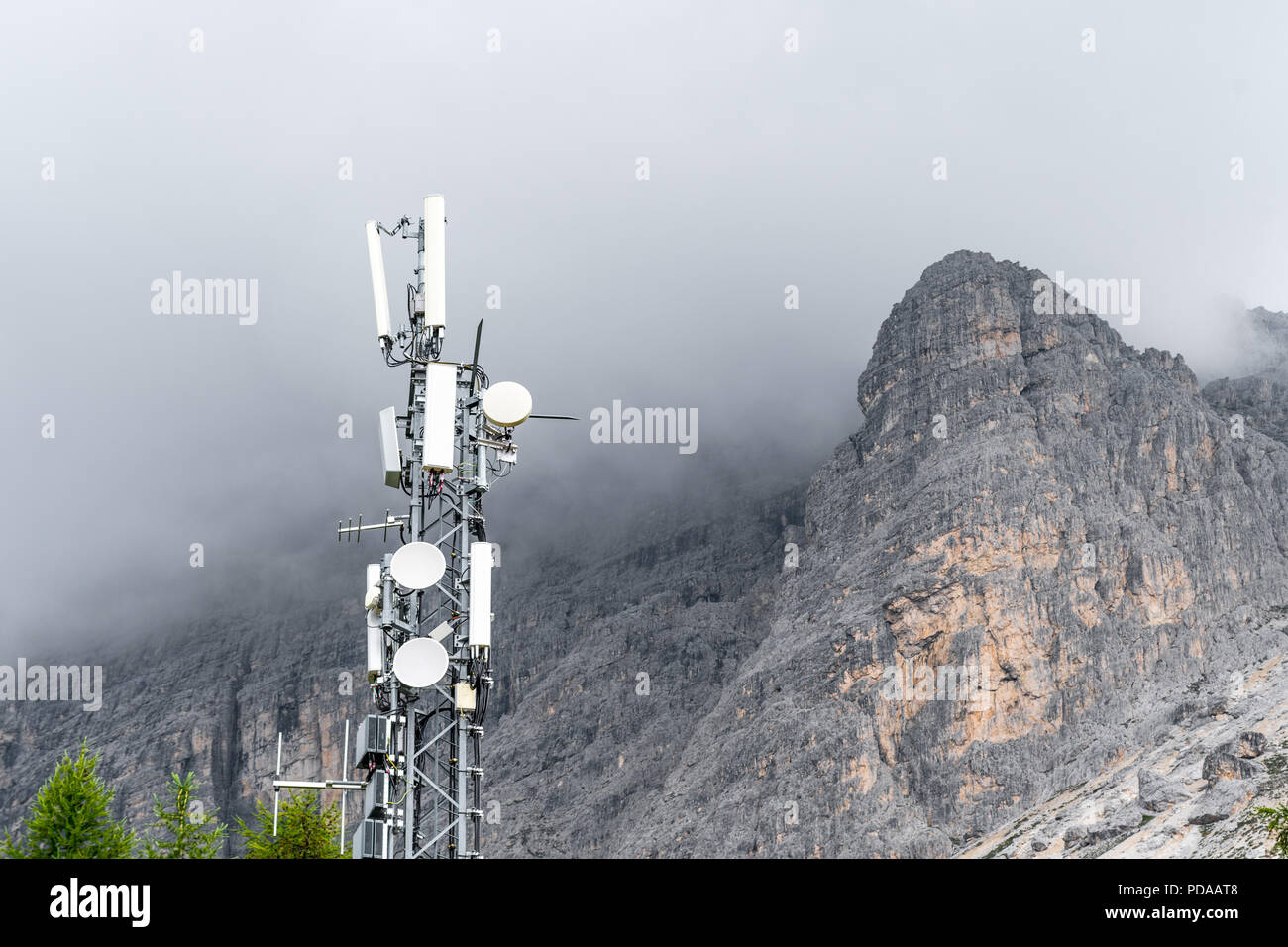 Sender auf einem Berg mit Gewitterwolken, die sich um einen Berg. Konzept der Störungen aufgrund von schlechtem Wetter Stockfoto