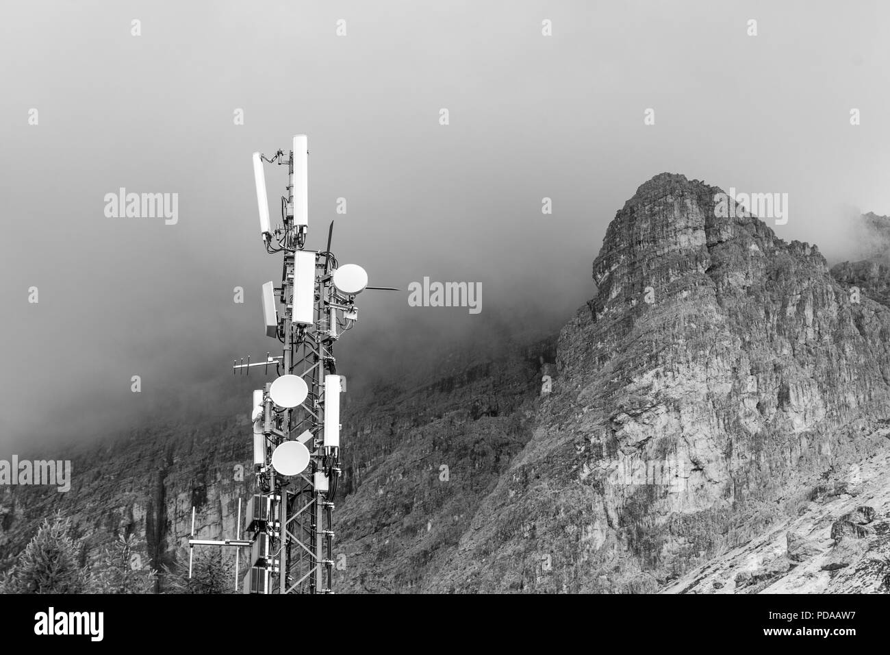 Sender auf einem Berg mit Gewitterwolken, die sich um einen Berg. Konzept der Störungen aufgrund von schlechtem Wetter Stockfoto