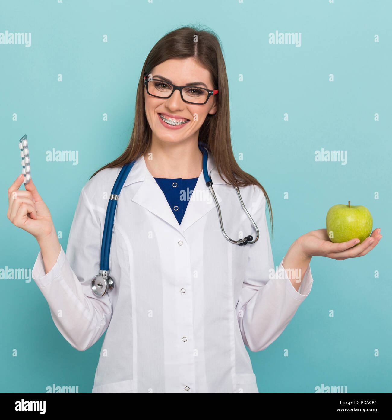 Ärztin in Gläsern mit Apple und Pillen Stockfoto Ärztin in Gläsern mit Apple und Pillen Stockfoto