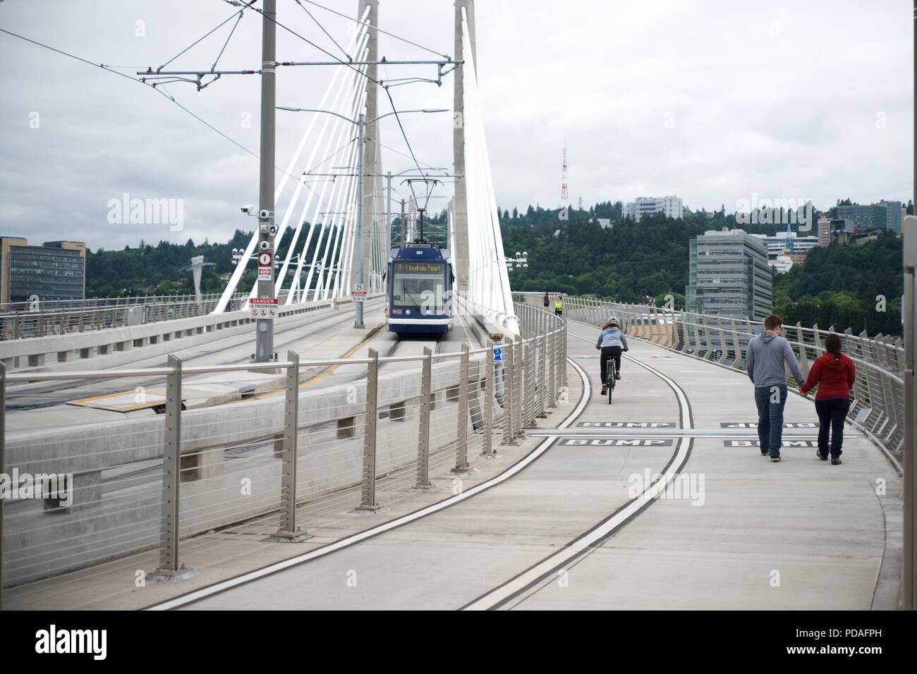 PORTLAND, Oregon, 16. Mai 2017, auf der Tilikum Kreuzung Brücke mit einer Straßenbahn, einen Radfahrer, und Leute wandern und joggen. Stockfoto