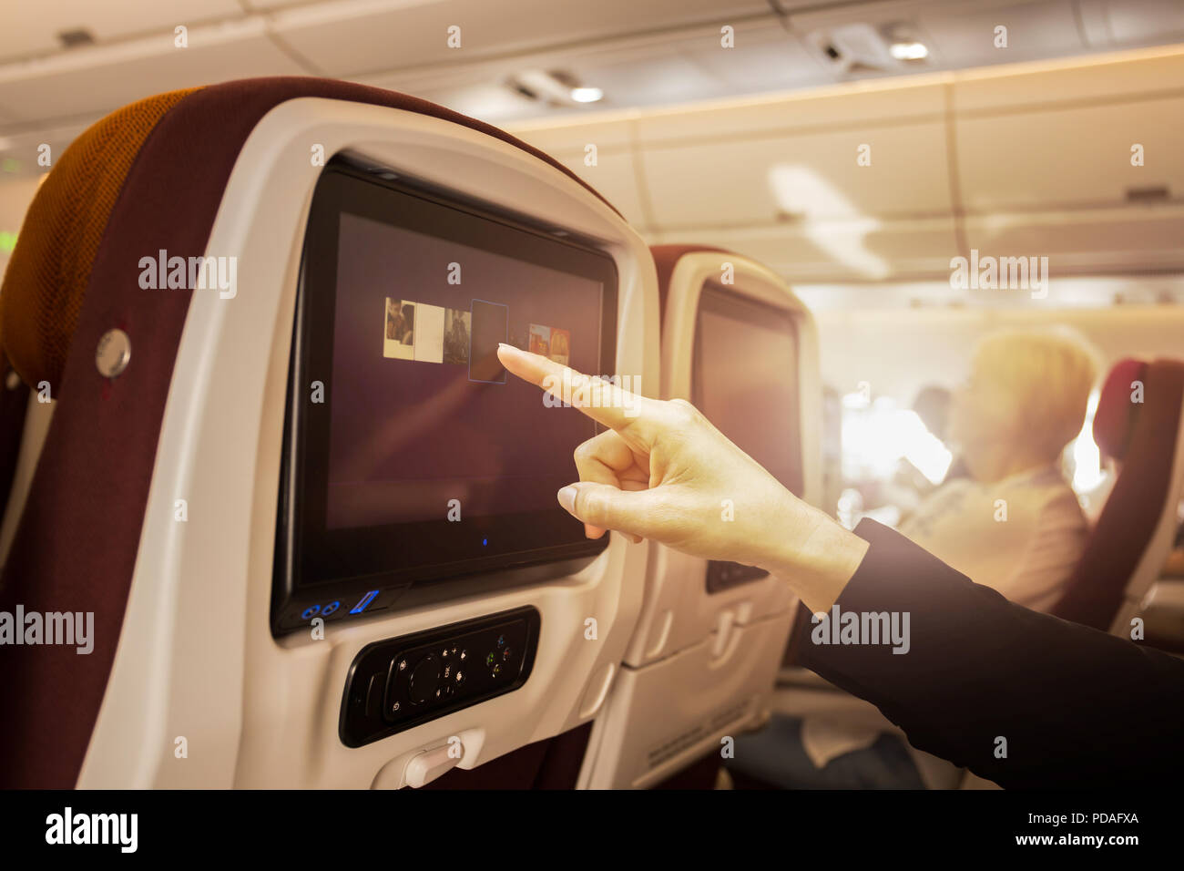 Hand berühren LCD-Bildschirm an der Unterhaltung in ein Flugzeug während des Fluges. Stockfoto