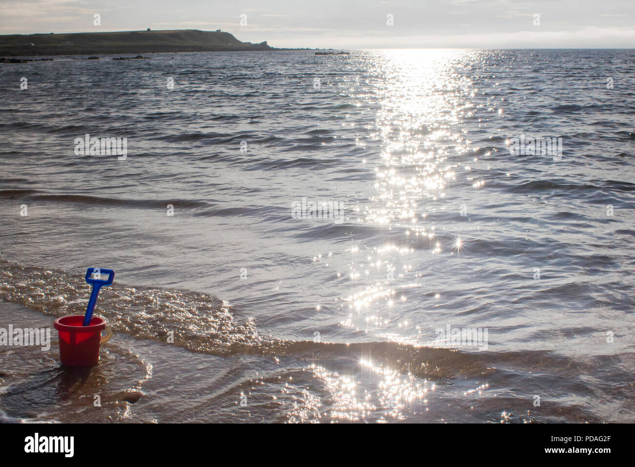 Eine Schaufel und Spaten sitzen auf einem Sandstrand an einem sonnigen Tag in Sutherland, Highlands Schottland. Stockfoto