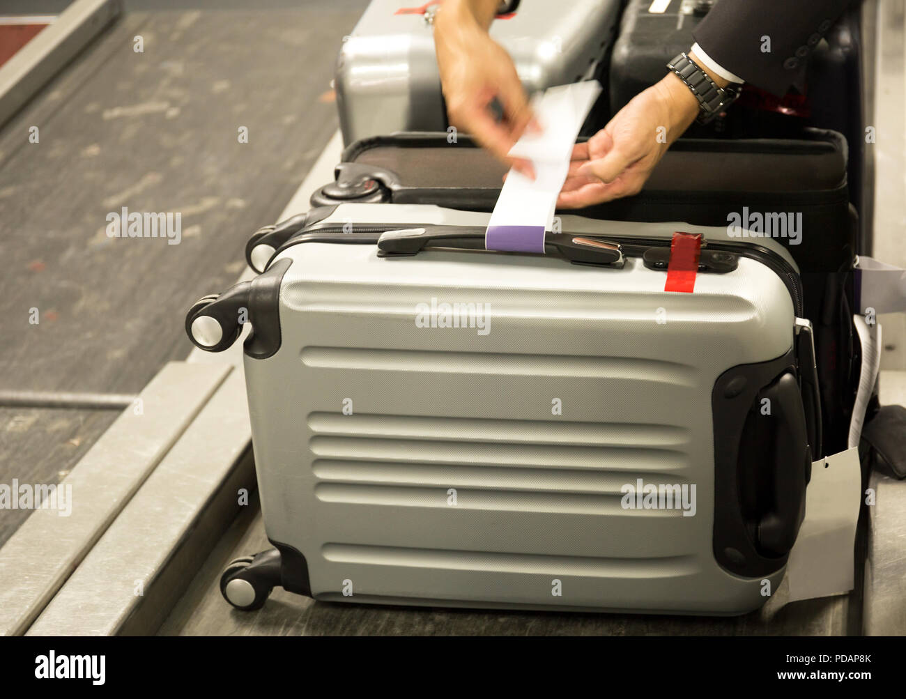 Check-in Mitarbeiter fügt einen Kofferanhänger, Koffer der Passagiere am  Flughafen Stockfotografie - Alamy