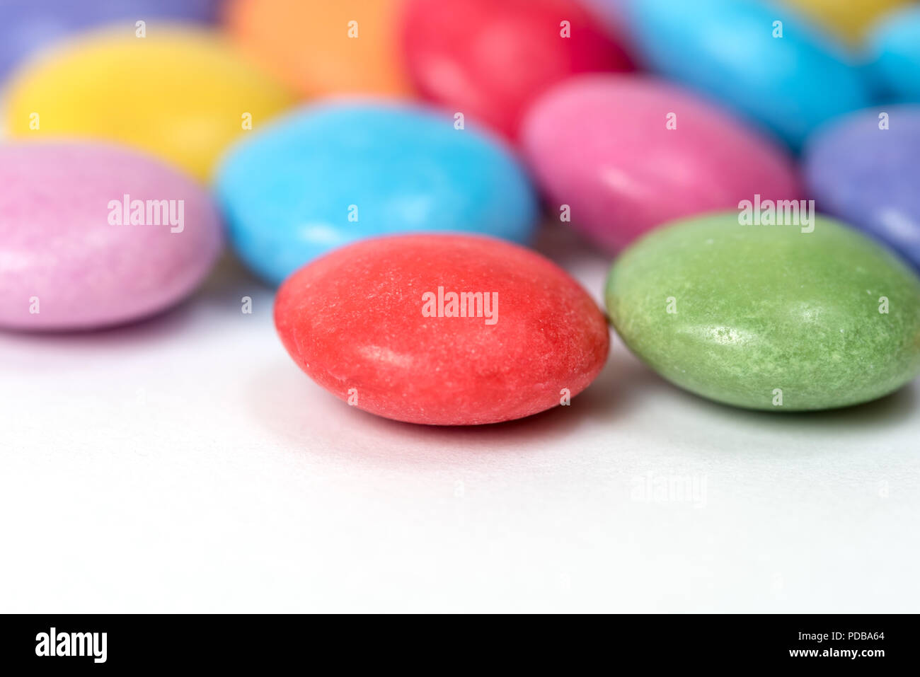 Nahaufnahme von Zucker überzogen Smarties Bonbons auf weißem Hintergrund Stockfoto