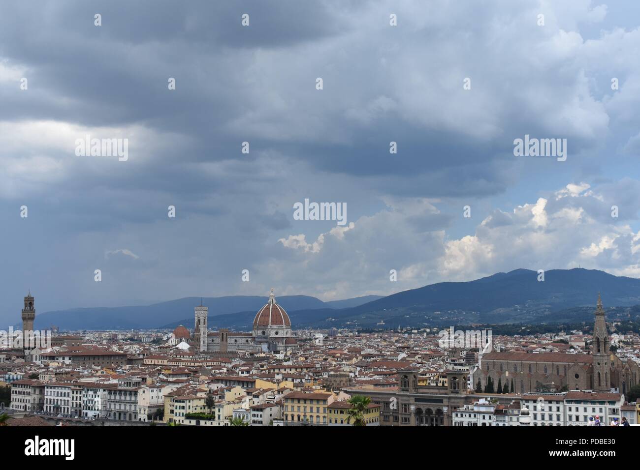 Stimmungsvolle Beleuchtung und Moody bewölkte Himmel über der Skyline von Florenz droht mit dem Dom und dem Turm, mit dem dunstigen toskanischen Hügel. Stockfoto