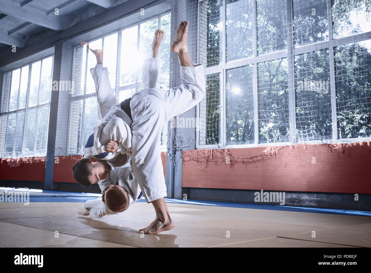 Zwei judo Kämpfer zeigt technische Fertigkeit beim Üben der Kampfkunst in einem Fight Club. Die beiden passen Männer in Uniform. kämpfen, Karate, Ausbildung, Kunst, Athlet, Wettbewerb Konzept Stockfoto