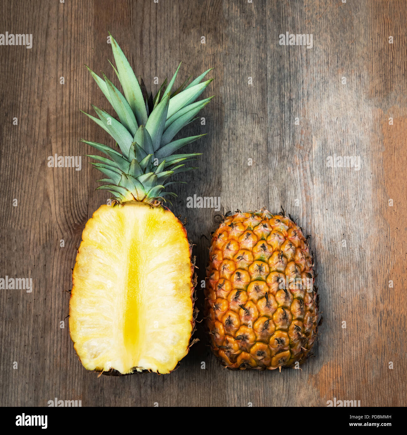Ananas Obst schneiden zwei Hälften top Holz- Hintergrund negativer Platz. Quadratische Komposition. Juicy organisch reif und süß gewachsen Stockfoto